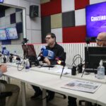 O presidente do CRMV-SP está junto a dois radialistas, no estúdio de gravação.