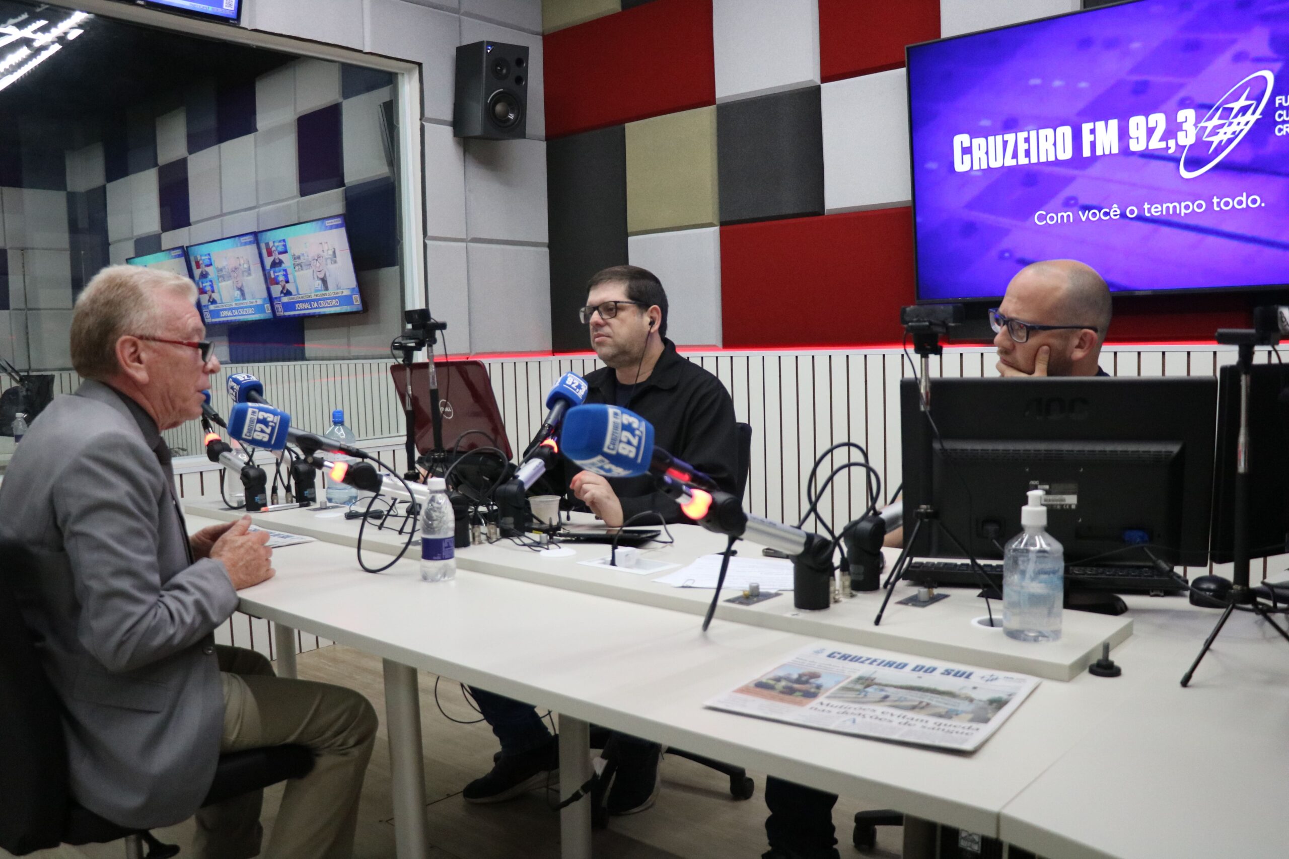 O presidente do CRMV-SP está junto a dois radialistas, no estúdio de gravação.