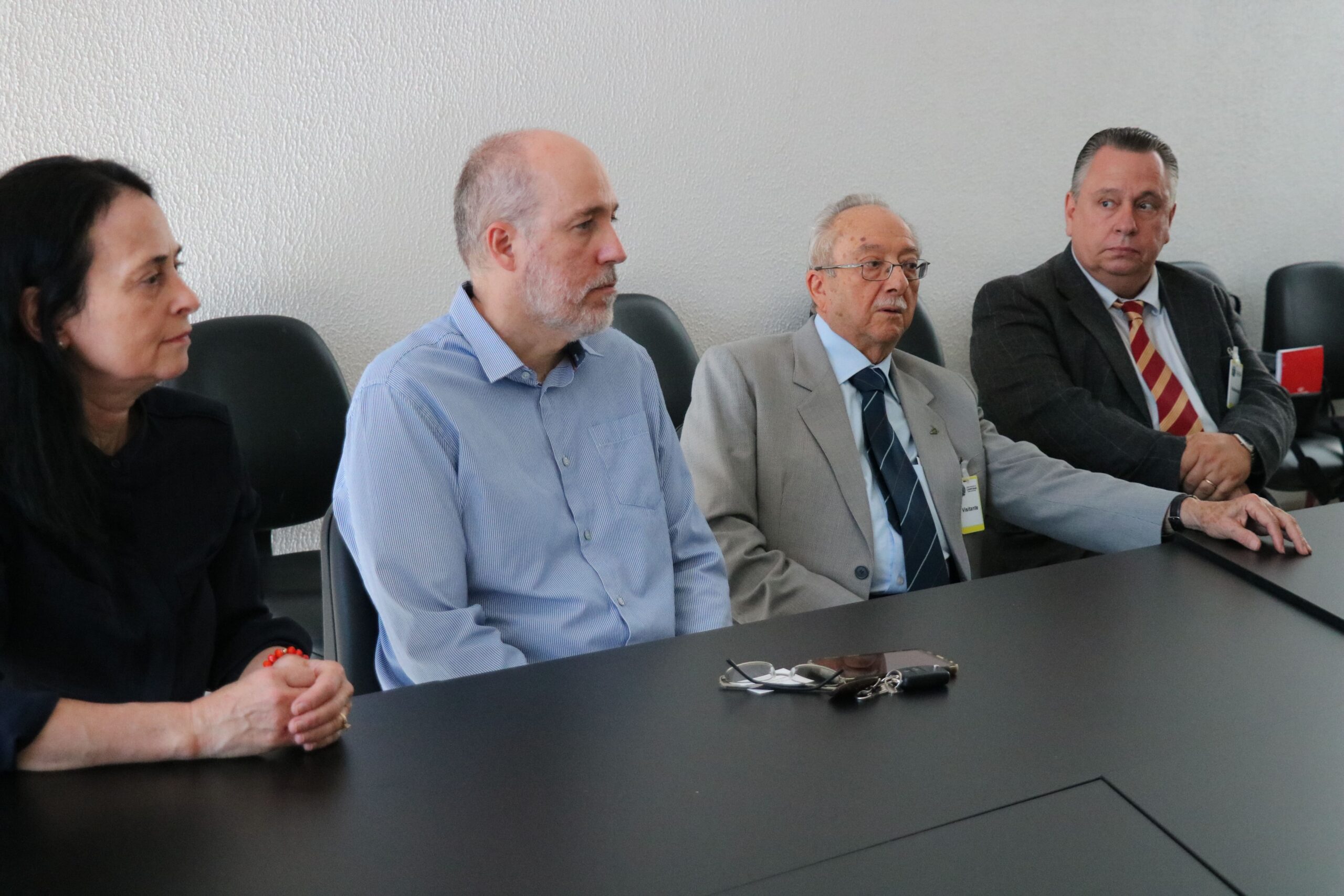 Na foto aparecem três homens e uma mulher sentados atrás de uma mesa preta. Trata-se do vereador por Campinas e sua suplente, e dois representantes do CRMV-SP.