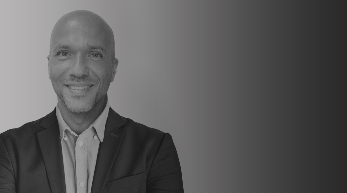 Na foto há um homem careca, de terno preto e camisa branca. Esse é o presidente da Comissão Fabiano Granville Ponce.