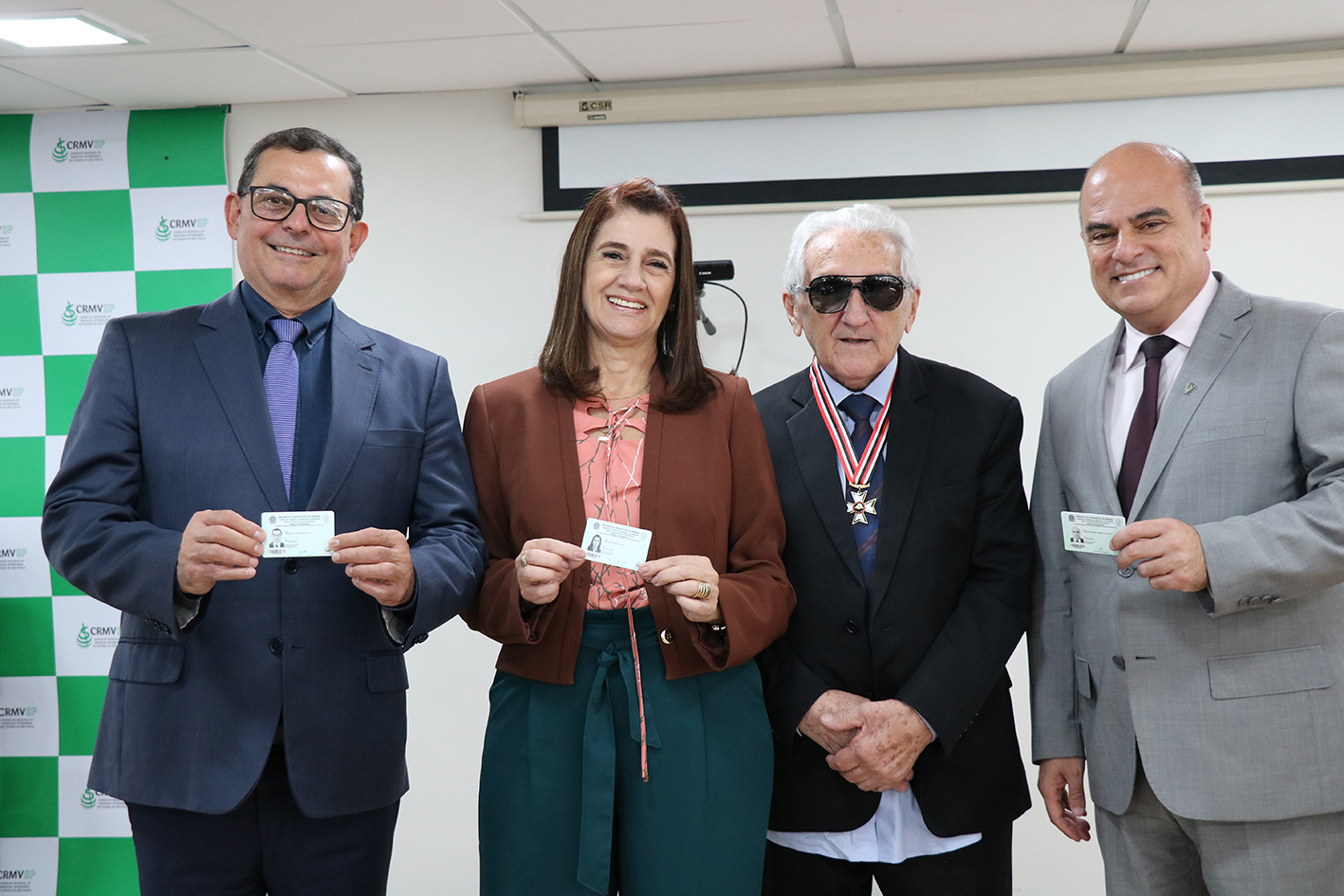 A foto mostra os membros da diretoria do CRMV-SP recebendo a cédula profissional do Doutor Francisco, presidente do CFMV.