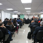 A imagem mostra os membros participantes sentados