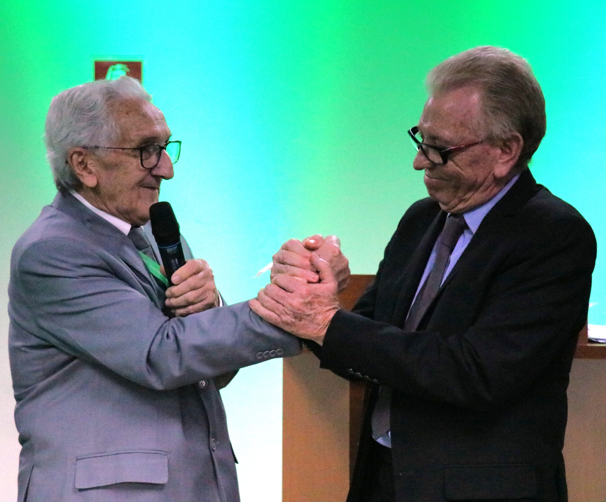 O presidente do Regional e o presidente do Federal dão as mãos e sorriem na foto.
