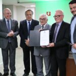Estão na foto o presidente do CFMV e ex-presidente do CRMV-SP, Francisco Cavalcanti de Almeida; o ex-presidente, Mário Eduardo Pulga; o presidente do Regional na atual gestão, Odemilson Donizete Mossero; o deputado federal, Arnaldo Jardim; o superintendente federal de Agricultura e Pecuária de São Paulo, Guilherme Campos; o médico-veterinário e vereador da cidade de São Paulo, Rodrigo Goulart. O presidente do CRMV-SP recebe a placa de homenagem da Câmara Municipal – voto de júbilo.