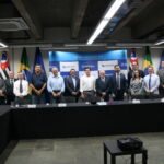 A imagem traz representantes do CRMV-SP e da Prefeitura de RIbeirão Preto. Eles posam para a foto todos juntos. Eles estão de pé, lado a lado, sendo 12 homens e uma mulher.