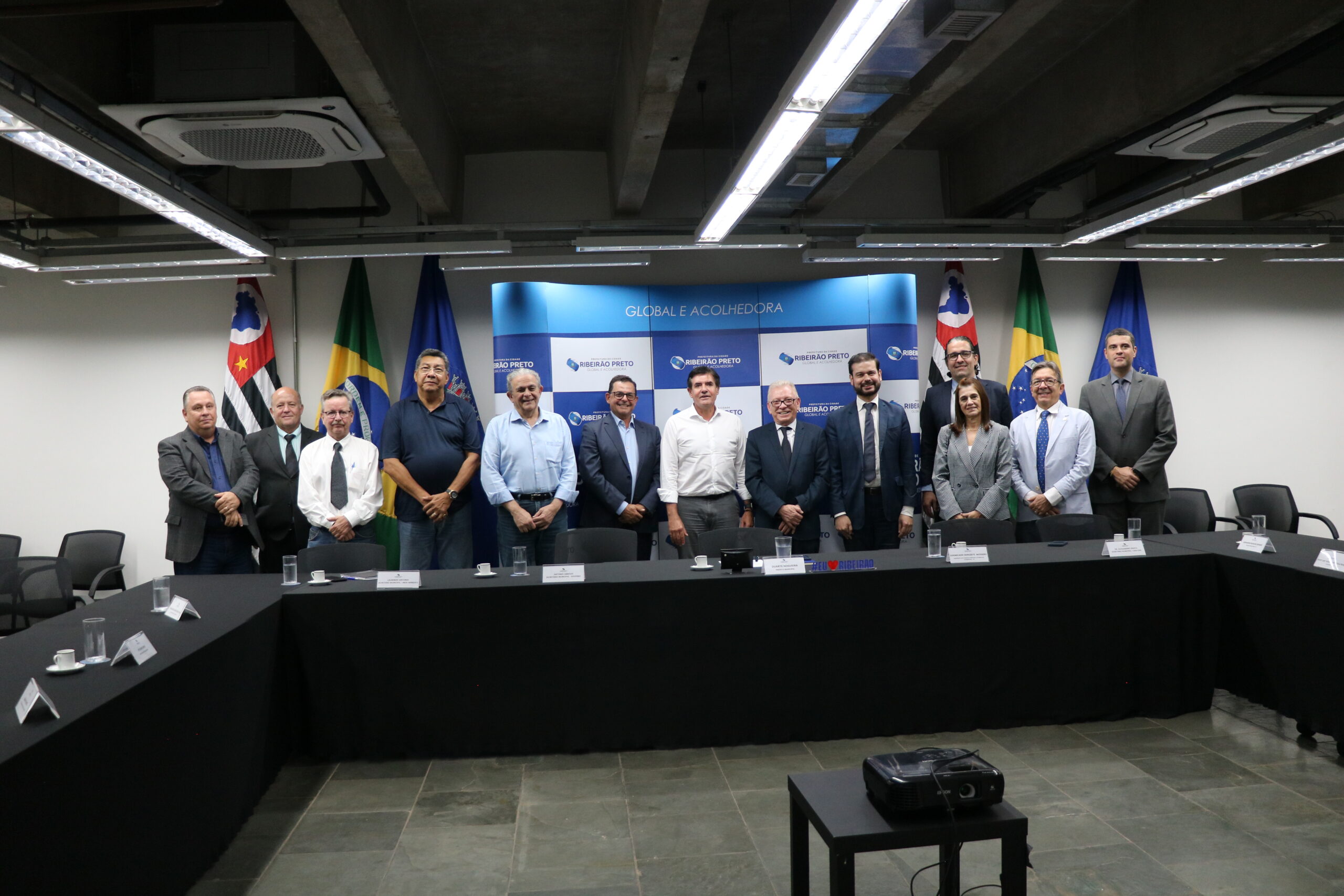 A imagem traz representantes do CRMV-SP e da Prefeitura de RIbeirão Preto. Eles posam para a foto todos juntos. Eles estão de pé, lado a lado, sendo 12 homens e uma mulher.