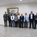 A imagem traz representantes do CRMV-SP e o vereador da cidade. Eles posam para a foto todos juntos, de pé. Na parede, atrás deles, um quadro retrata uma casa grande.