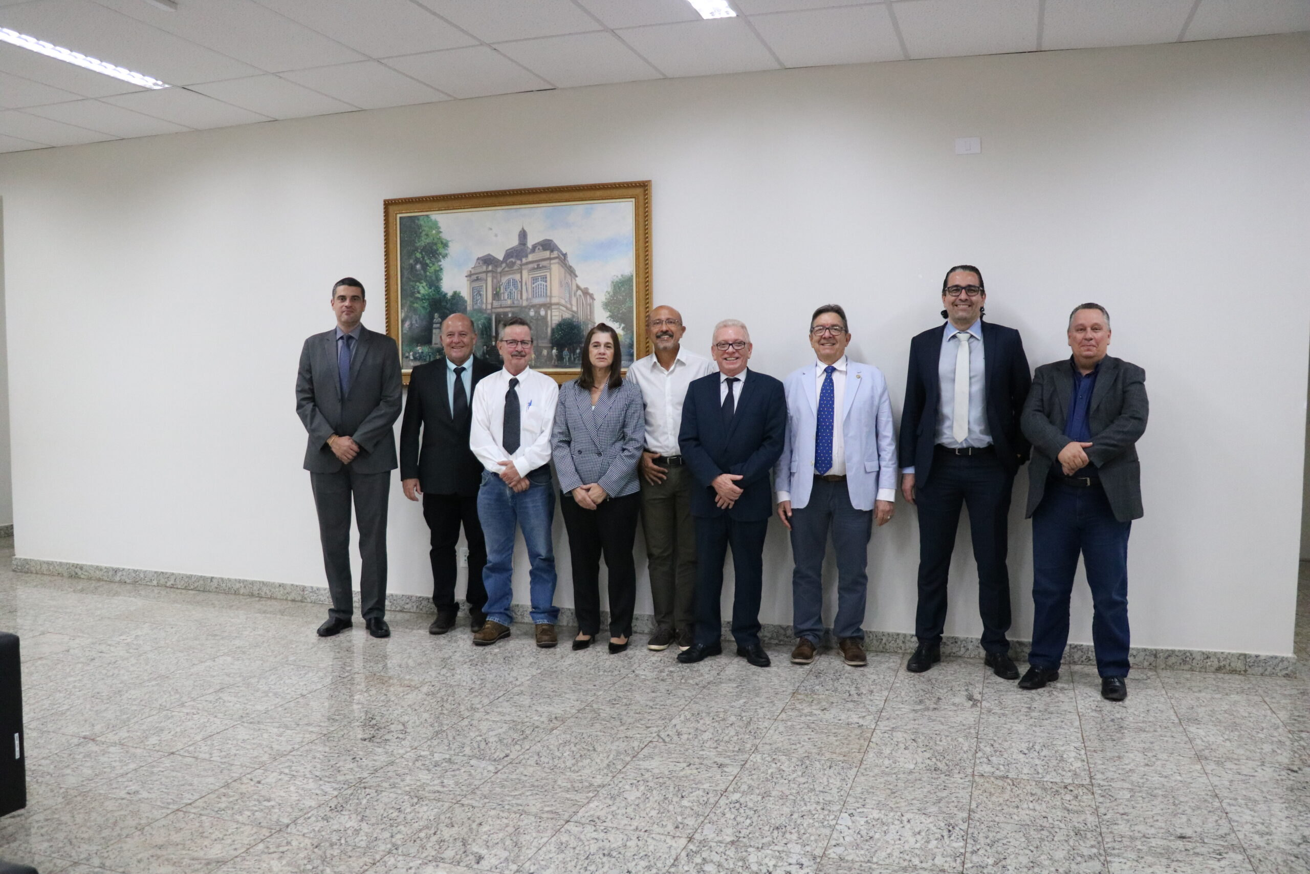 A imagem traz representantes do CRMV-SP e o vereador da cidade. Eles posam para a foto todos juntos, de pé. Na parede, atrás deles, um quadro retrata uma casa grande.