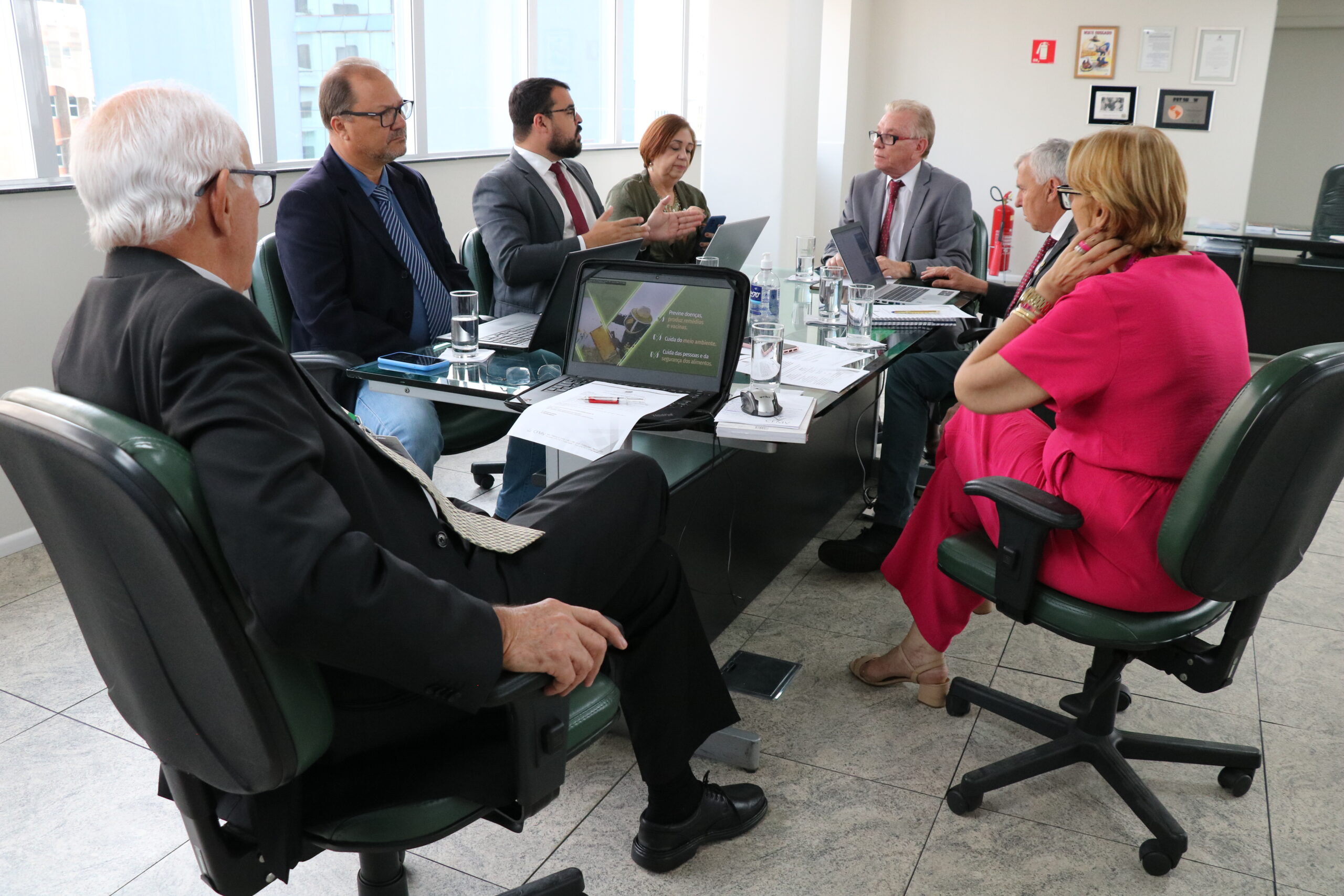 Na foto, estão sentados e conversam os participantes da reunião do PRODES: o presidente do CRMV-SP, Odemilson Donizete Mossero (primeiro ao fundo); o conselheiro do CFMV, Paulo Araújo de Guerra (à direita); a vice-presidente do CFMV, Ana Elisa de Souza Almeida; o conselheiro do CFMV, Marcílio Magalhães Vaz de Oliveira (primeiro, à frente); o presidente do CRMV-BA, Altair Santana de Oliveira (primeiro, à direita); o assessor administrativo, chefe do Núcleo de Apoio aos Regionais (NAR) do CFMV, Igor Pinto de Andrade; e a presidente do CRMV-PE, Maria Elisa Araújo.