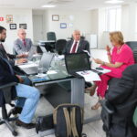 Na foto, estão sentados e conversam os participantes da reunião do PRODES: o presidente do CRMV-SP, Odemilson Donizete Mossero (primeiro ao fundo); o conselheiro do CFMV, Paulo Araújo de Guerra (à direita); a vice-presidente do CFMV, Ana Elisa de Souza Almeida; o conselheiro do CFMV, Marcílio Magalhães Vaz de Oliveira (primeiro, à frente); o presidente do CRMV-BA, Altair Santana de Oliveira (primeiro, à direita); o assessor administrativo, chefe do Núcleo de Apoio aos Regionais (NAR) do CFMV, Igor Pinto de Andrade; e a presidente do CRMV-PE, Maria Elisa Araújo.