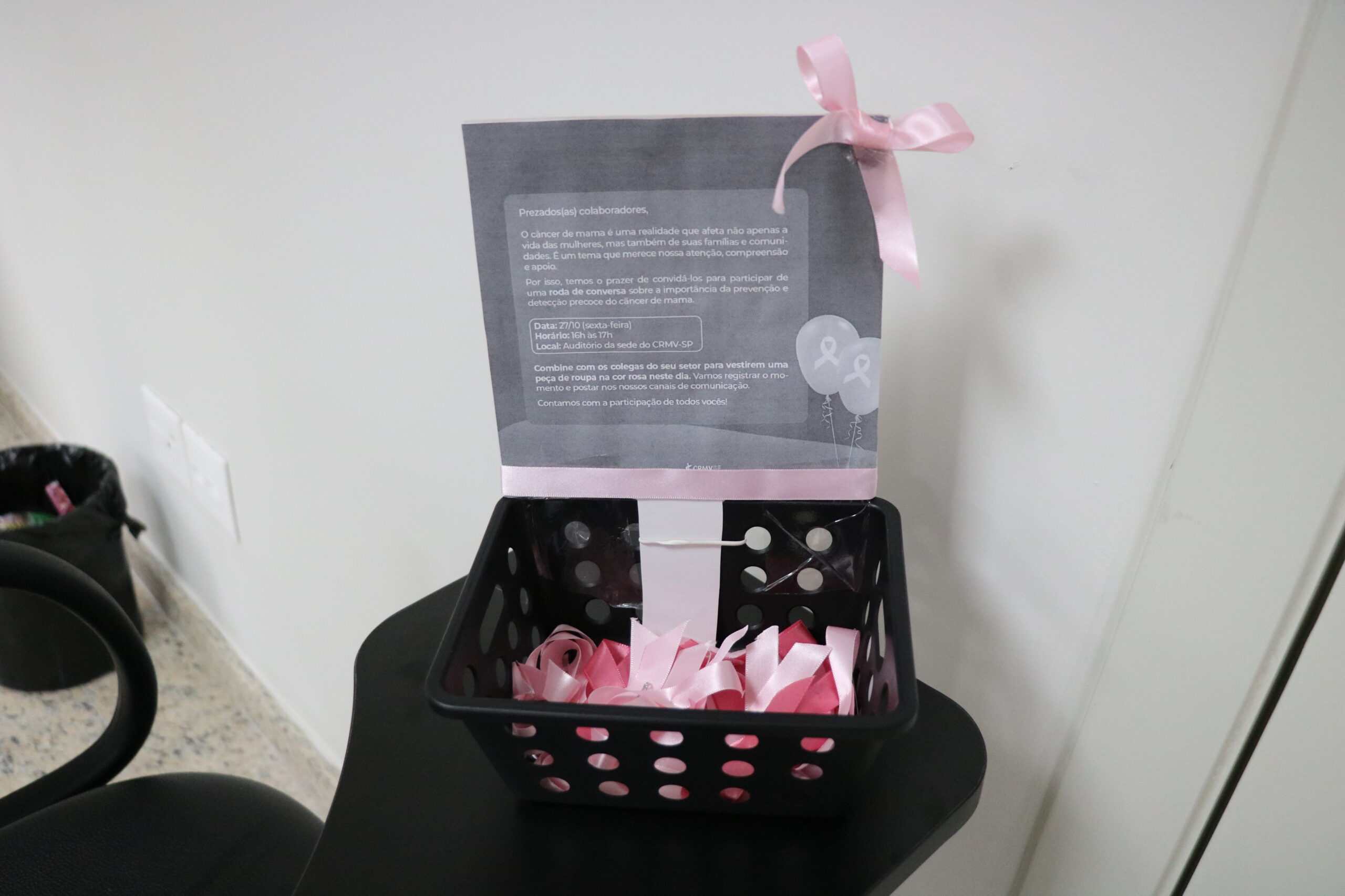 Na foto, cesta com fitas símbolo da campanha, que é laço rosa.