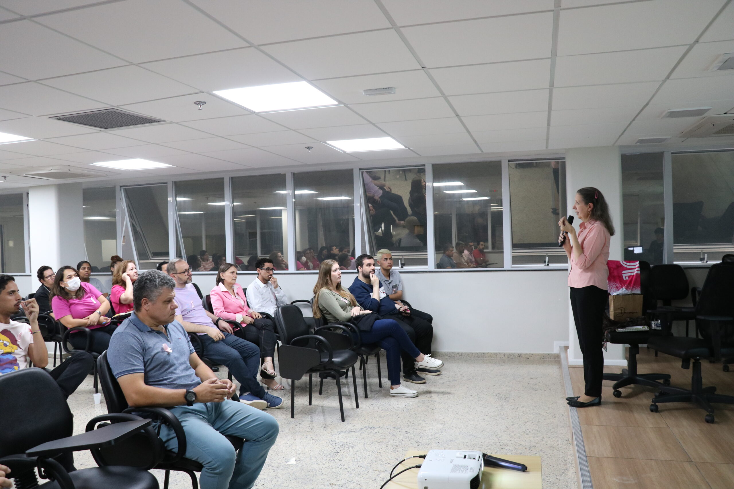 Na foto, colaboradores da autarquia, que compareceram vestindo peças de roupa com a cor rosa, e a palestrante e supervisora de gestão de pessoas, Rosana Souto, que dirigiu o encontro, contando sua experiência pessoal e seu trabalho para a conscientização sobre o câncer de mama.