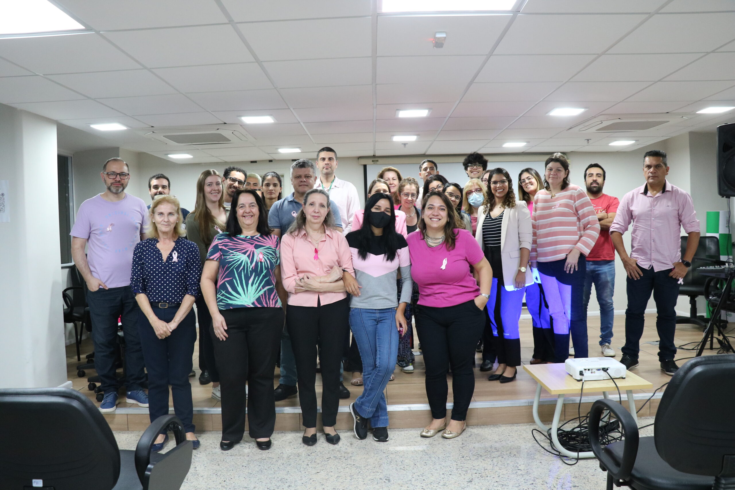 Na foto, posam colaboradores da autarquia, vestindo peças de roupa na cor rosa.