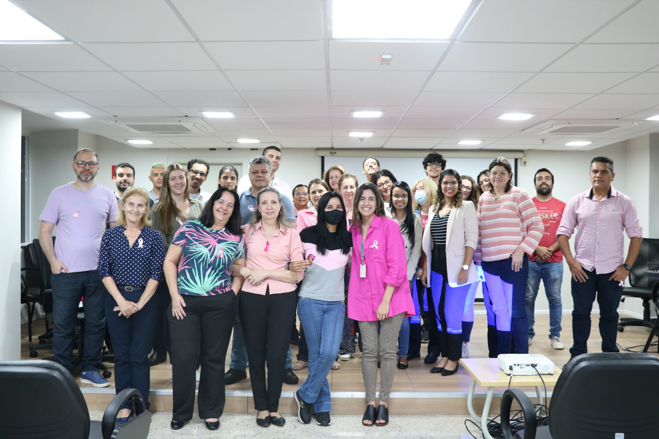 Colaboradores do CRMV-SP posam para a foto, vestindo roupa com a cor rosa.