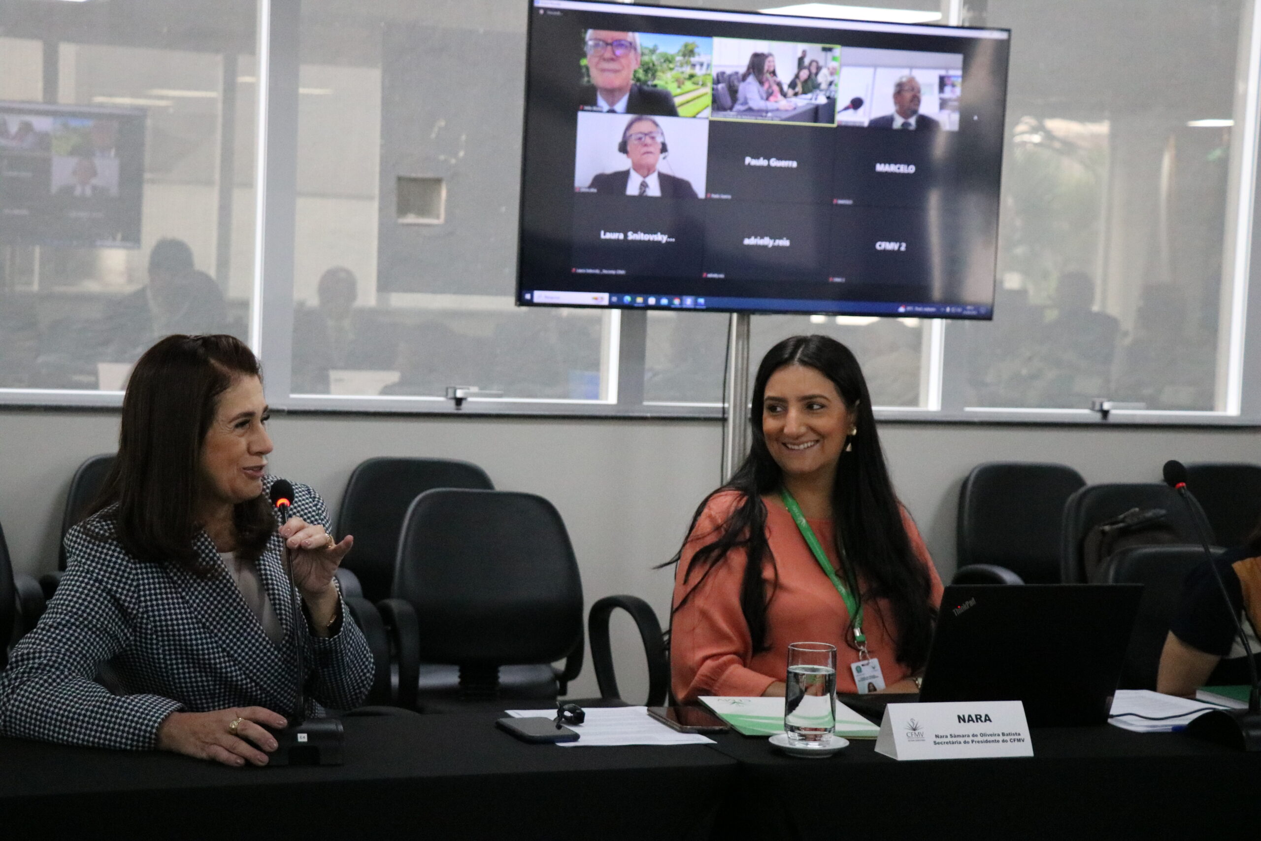 Na foto, estão duas mulheres do plenário sentadas na sala.
