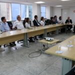 Visão lateral da sala. Em que é possível ver os presentes em dois dos lados do "U" formado pela disposição das mesas. No canto direito da imagem, o presidente do CRMV-SP fala do microfone.