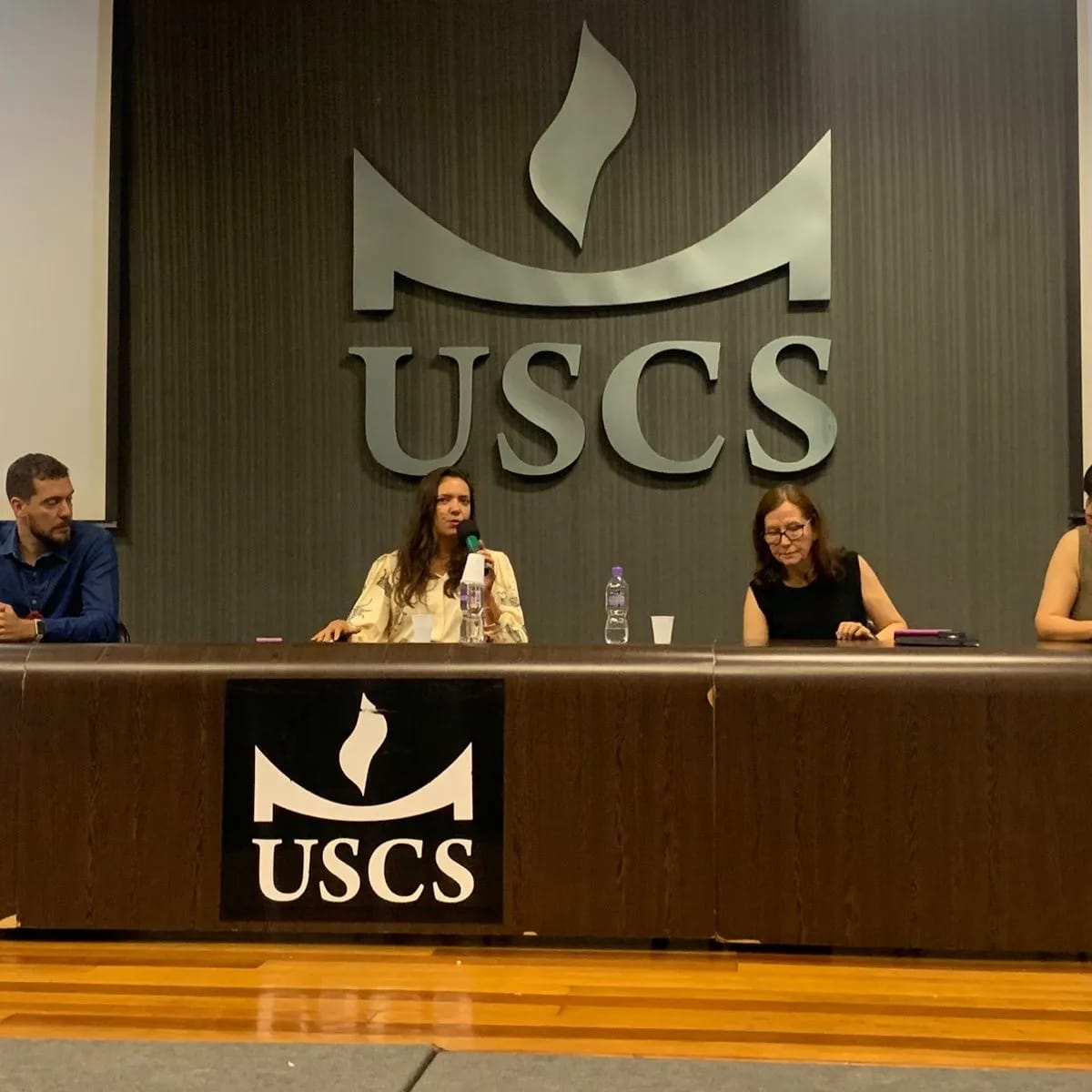 Na foto, membros da Comissão estão sentados no palco do evento.