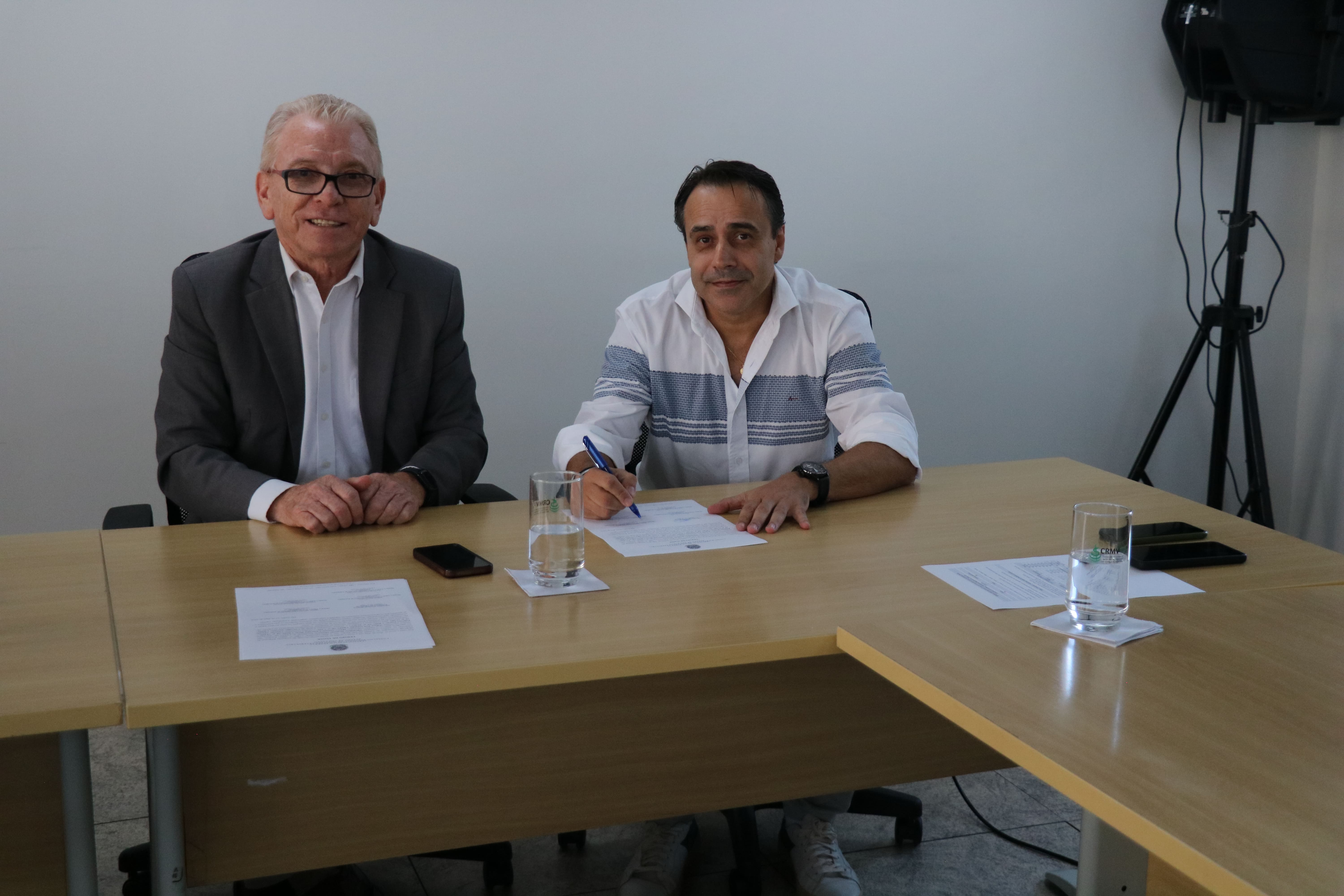 Na foto, o médico-veterinário Marco Antônio Chiaradia Berti assina a posse como membro da Comissão de Entidades Veterinárias Regionais do Estado de São Paulo do CRMV-SP, ao lado do presidente do CRMV-SP, Odemilson Donizete Mossero.