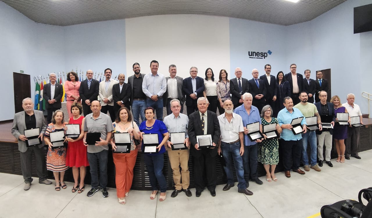 Profissionais que fizeram e continuam fazendo parte da história do Hospital Veterinário da FCAV-Unesp, campus de Jaboticabal, seguram placas em homenagem a suas contribuições valiosas ao hospital veterinário.