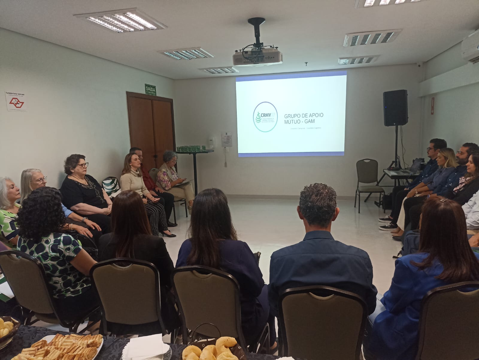 Pessoas sentadas em semicírculo durante reunião do Grupo de Apoio Mútuo(GAM).