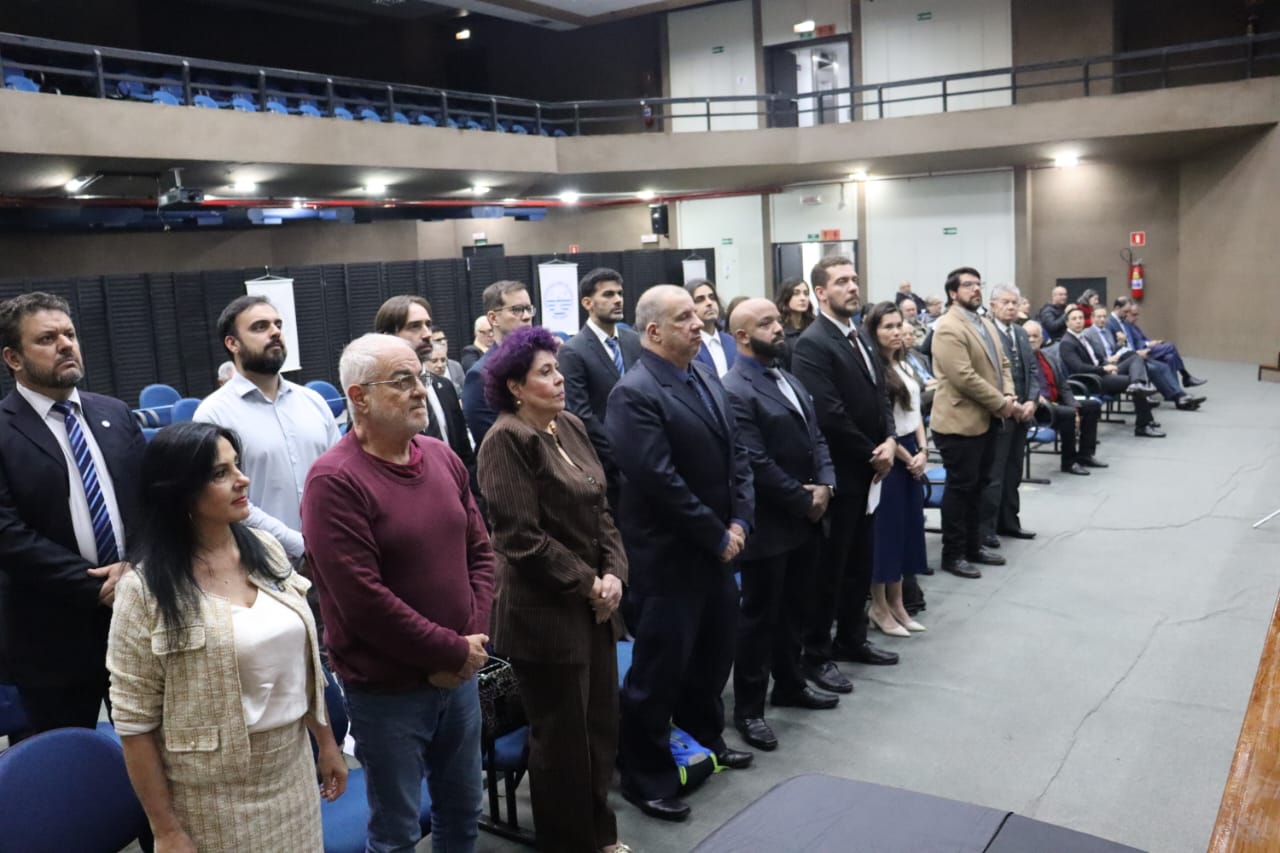 No auditório, a plateia em pé, formada por homens e mulheres, durante solenidade de posse da nova Diretoria Executiva da Sindicato.