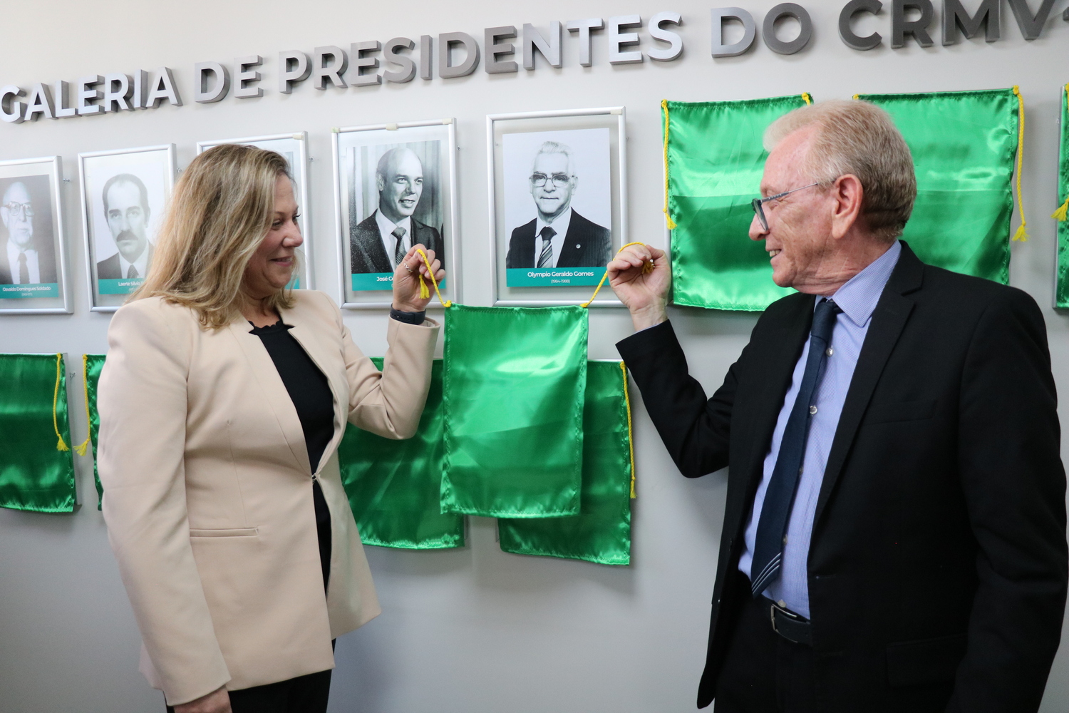 O presidente do CRMV-SP descerra foto na Galeria de Presidentes, ao lado de representante do homenageado.