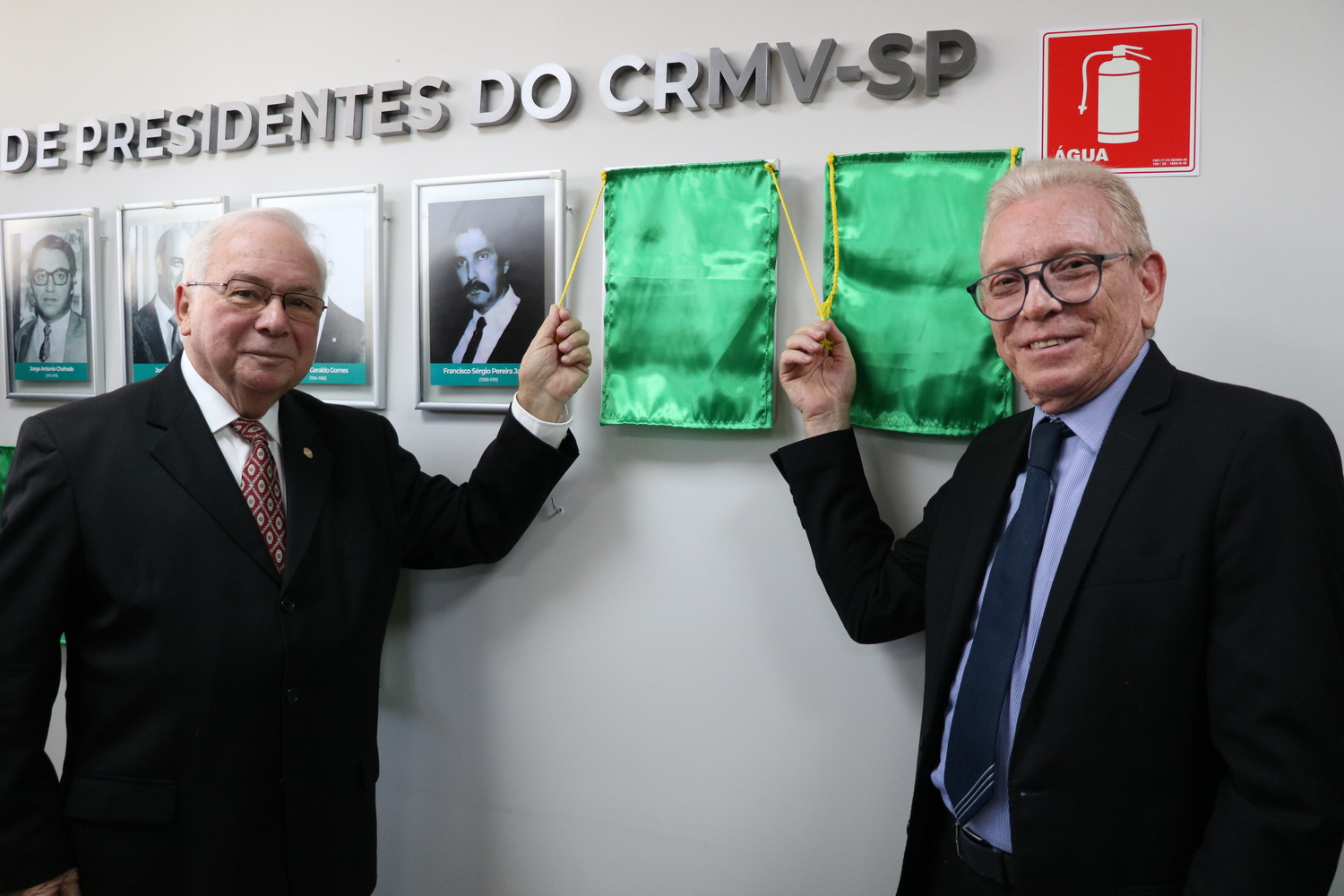 O presidente do CRMV-SP descerra foto na Galeria de Presidentes, ao lado de ex-presidente homenageado.