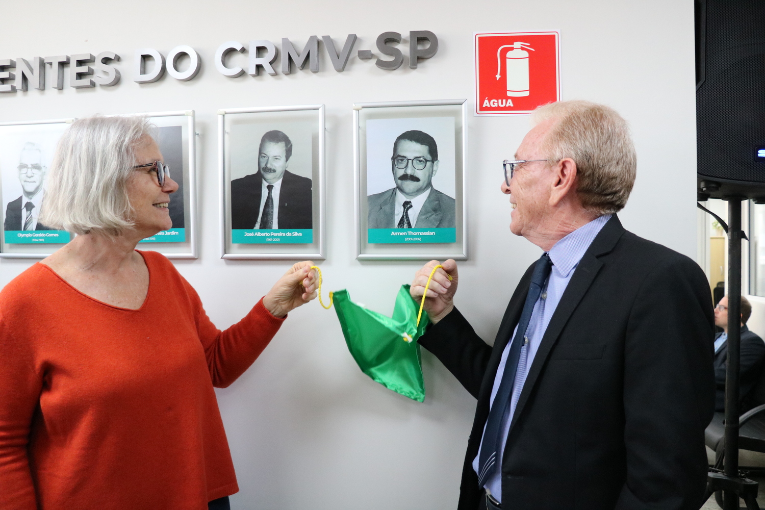 O presidente do CRMV-SP descerra foto na Galeria de Presidentes, ao lado de representante do homenageado.