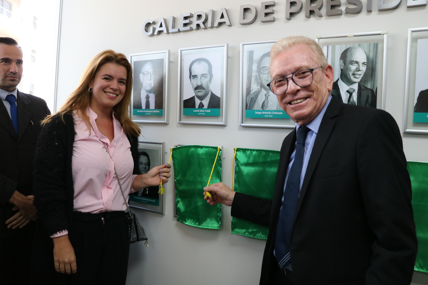 O presidente do CRMV-SP descerra foto na Galeria de Presidentes, ao lado de representante do homenageado.