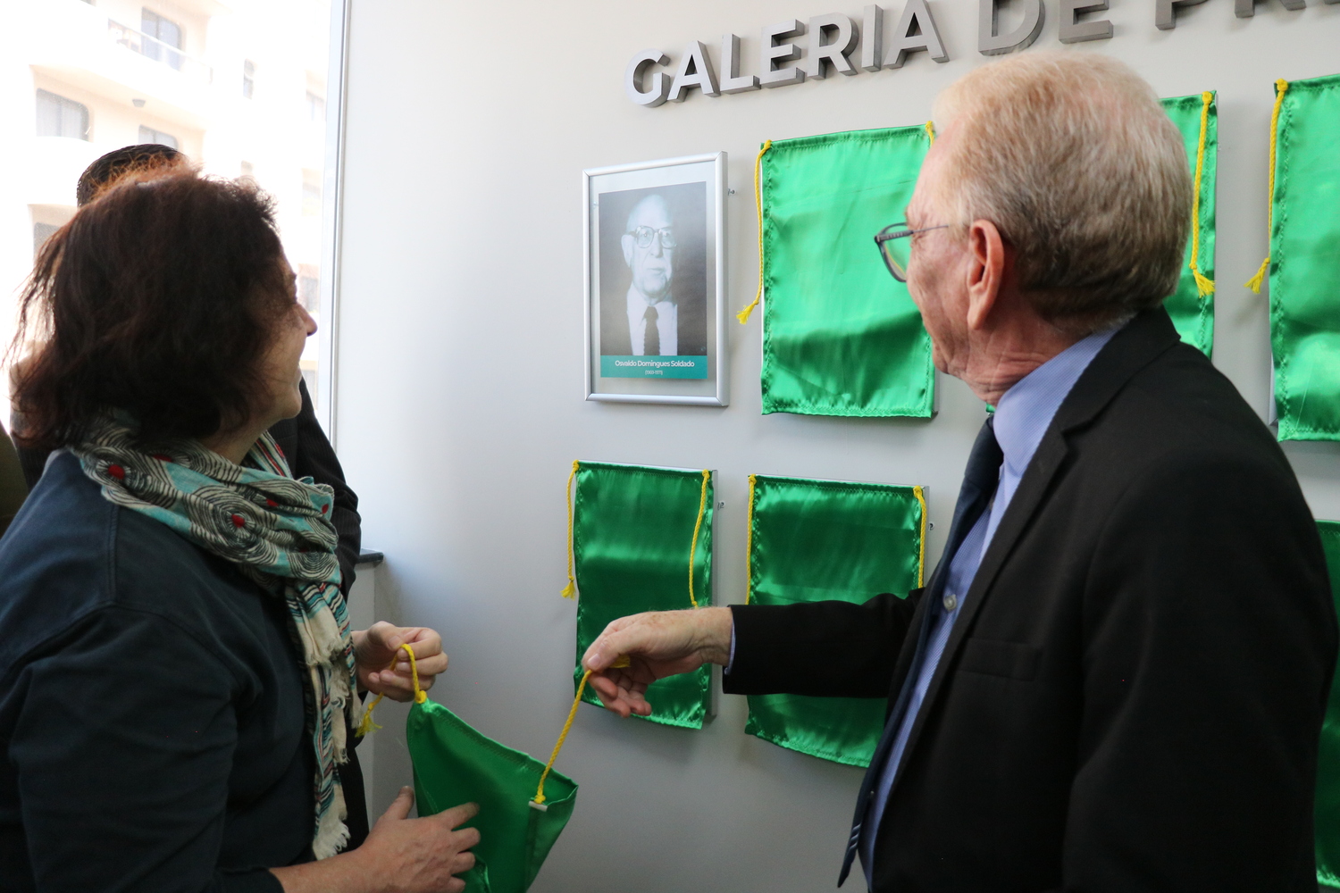 O presidente do CRMV-SP descerra foto na Galeria de Presidentes, ao lado de representante do homenageado.
