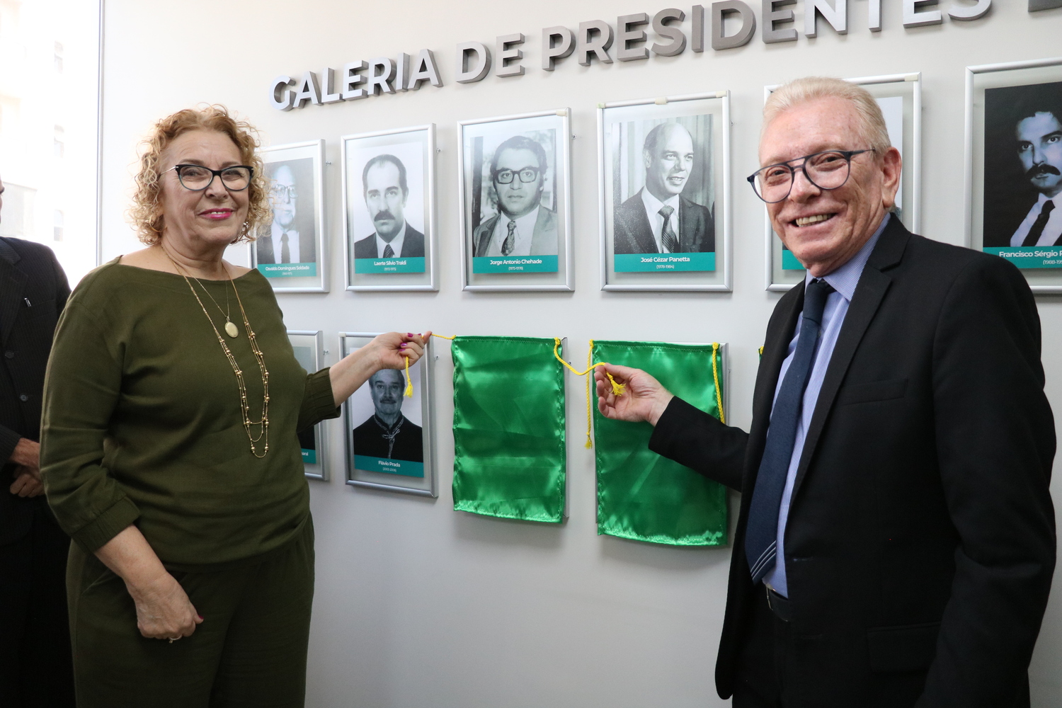 O presidente do CRMV-SP descerra foto na Galeria de Presidentes, ao lado de representante do homenageado.