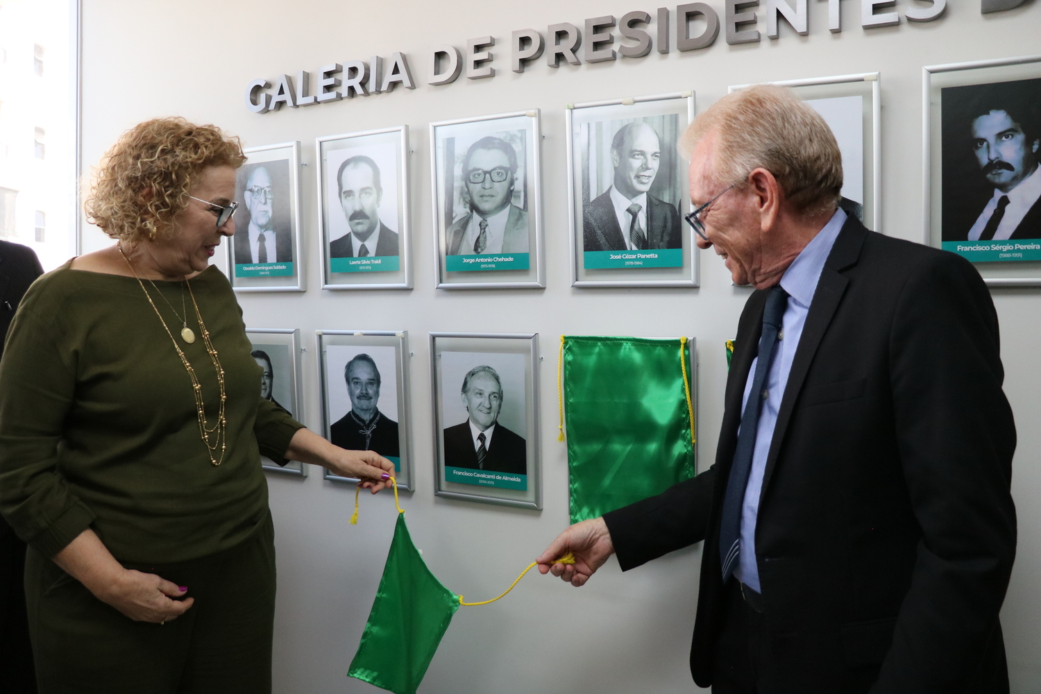 O presidente do CRMV-SP descerra foto na Galeria de Presidentes, ao lado de representante do homenageado.