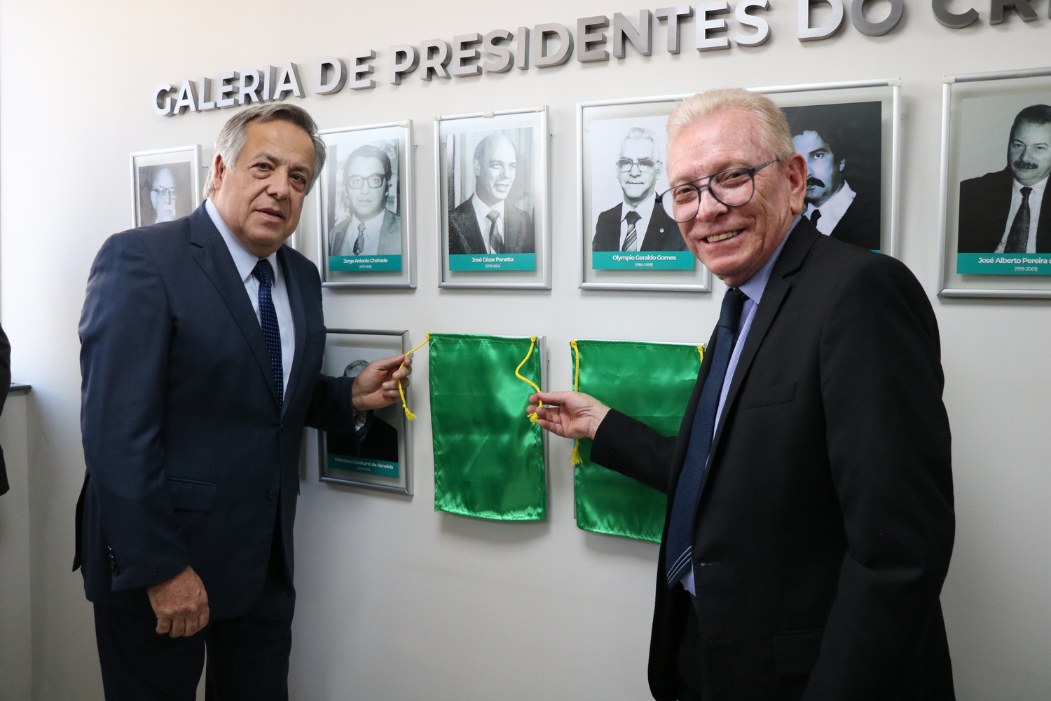 O presidente do CRMV-SP descerra foto na Galeria de Presidentes, ao lado de ex-presidente homenageado.