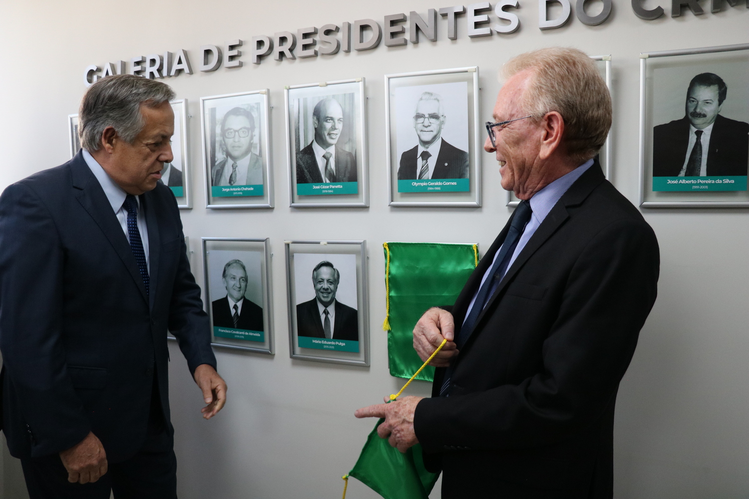 O presidente do CRMV-SP descerra foto na Galeria de Presidentes, ao lado de ex-presidente homenageado.
