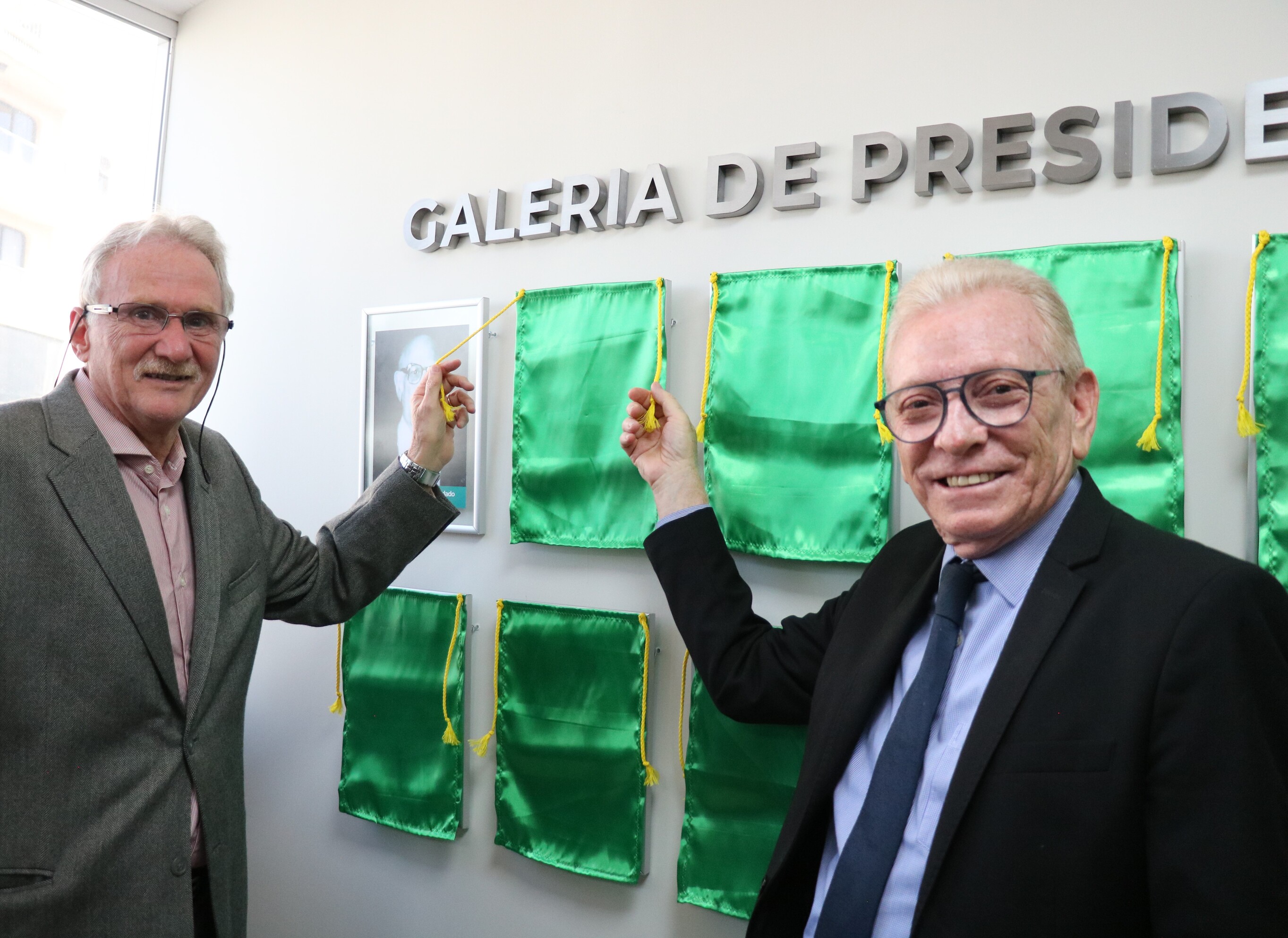 O presidente do CRMV-SP descerra foto na Galeria de Presidentes, ao lado de representante do homenageado.