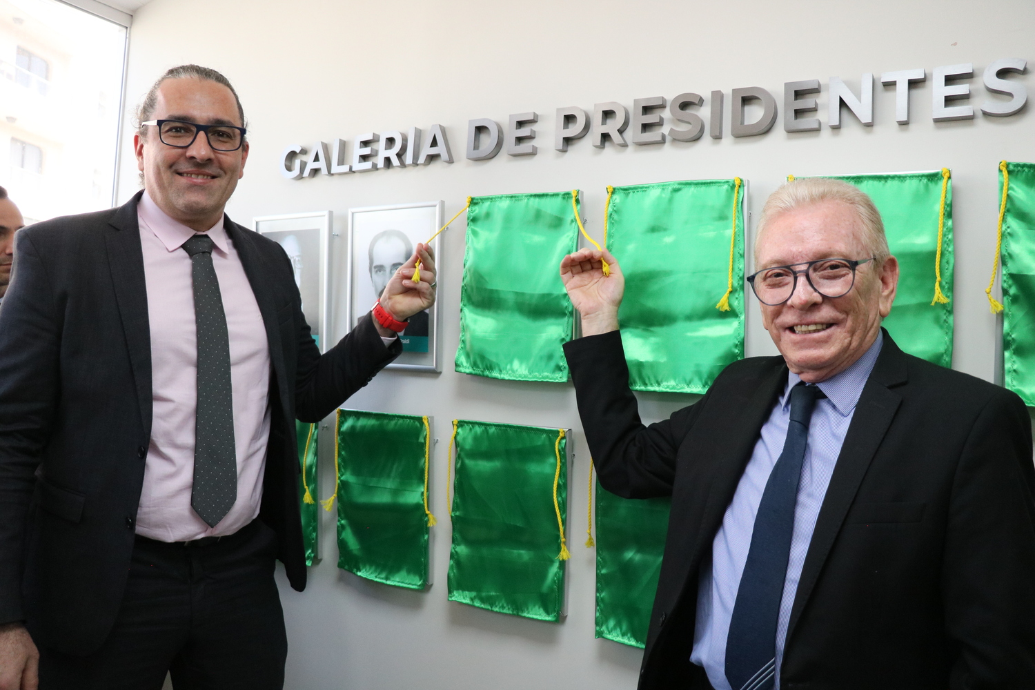 O presidente do CRMV-SP descerra foto na Galeria de Presidentes, ao lado de representante do homenageado.