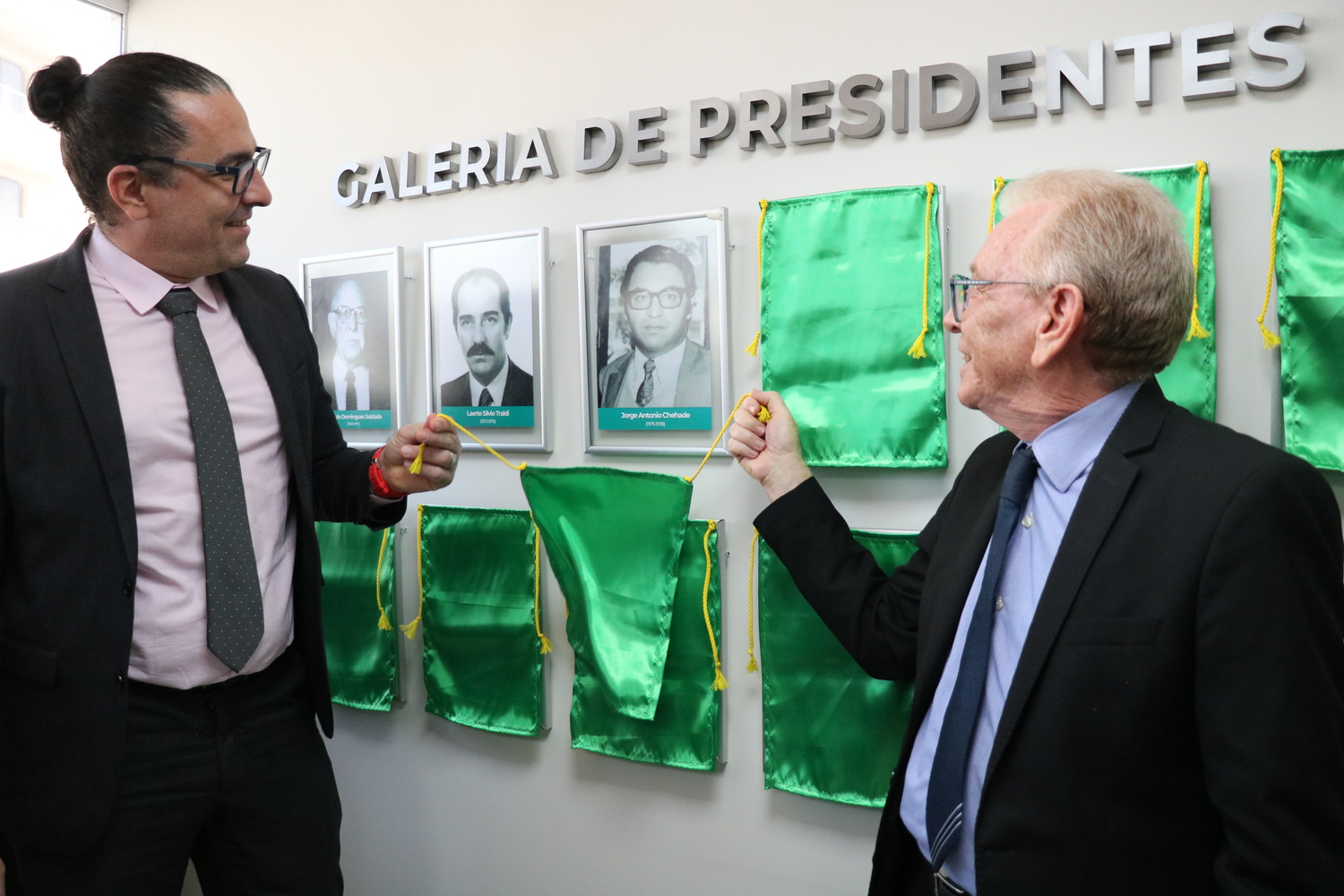 O presidente do CRMV-SP descerra foto na Galeria de Presidentes, ao lado de representante do homenageado.