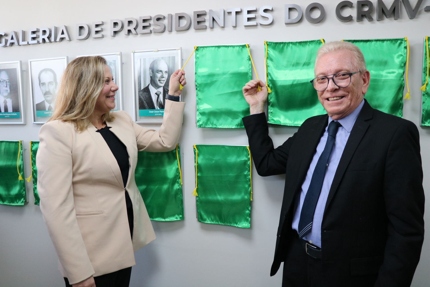 O presidente do CRMV-SP descerra foto na Galeria de Presidentes, ao lado de representante do homenageado.