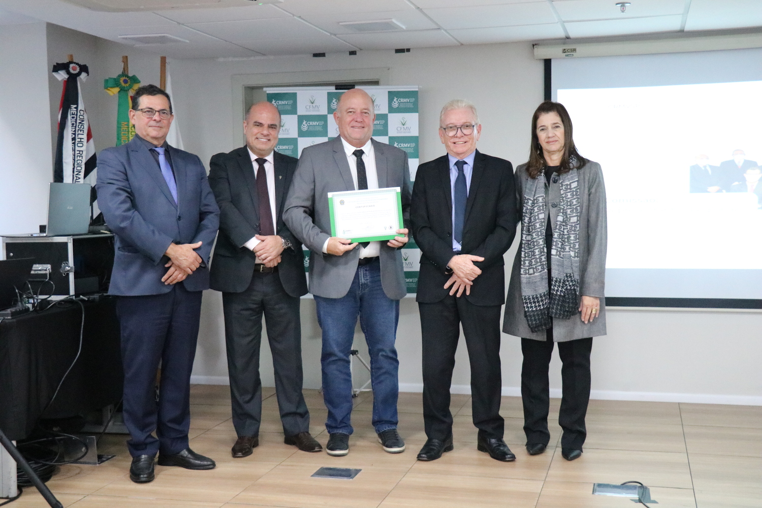 No palco, os membros da Diretoria Executiva do CRMV-SP posam ao lado de um dos integrantes da Comissão Técnica de Representantes Regionais, homenageado com certificado em reconhecimento ao trabalho desempenhado.