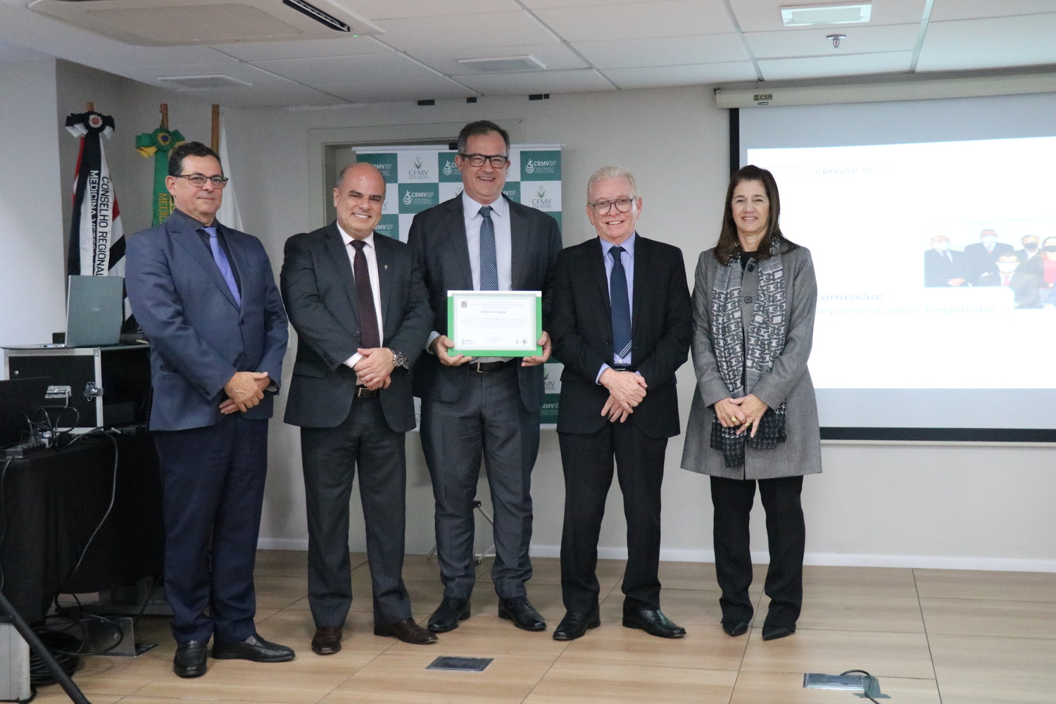 No palco, os membros da Diretoria Executiva do CRMV-SP posam ao lado de um dos integrantes da Comissão Técnica de Representantes Regionais, homenageado com certificado em reconhecimento ao trabalho desempenhado.