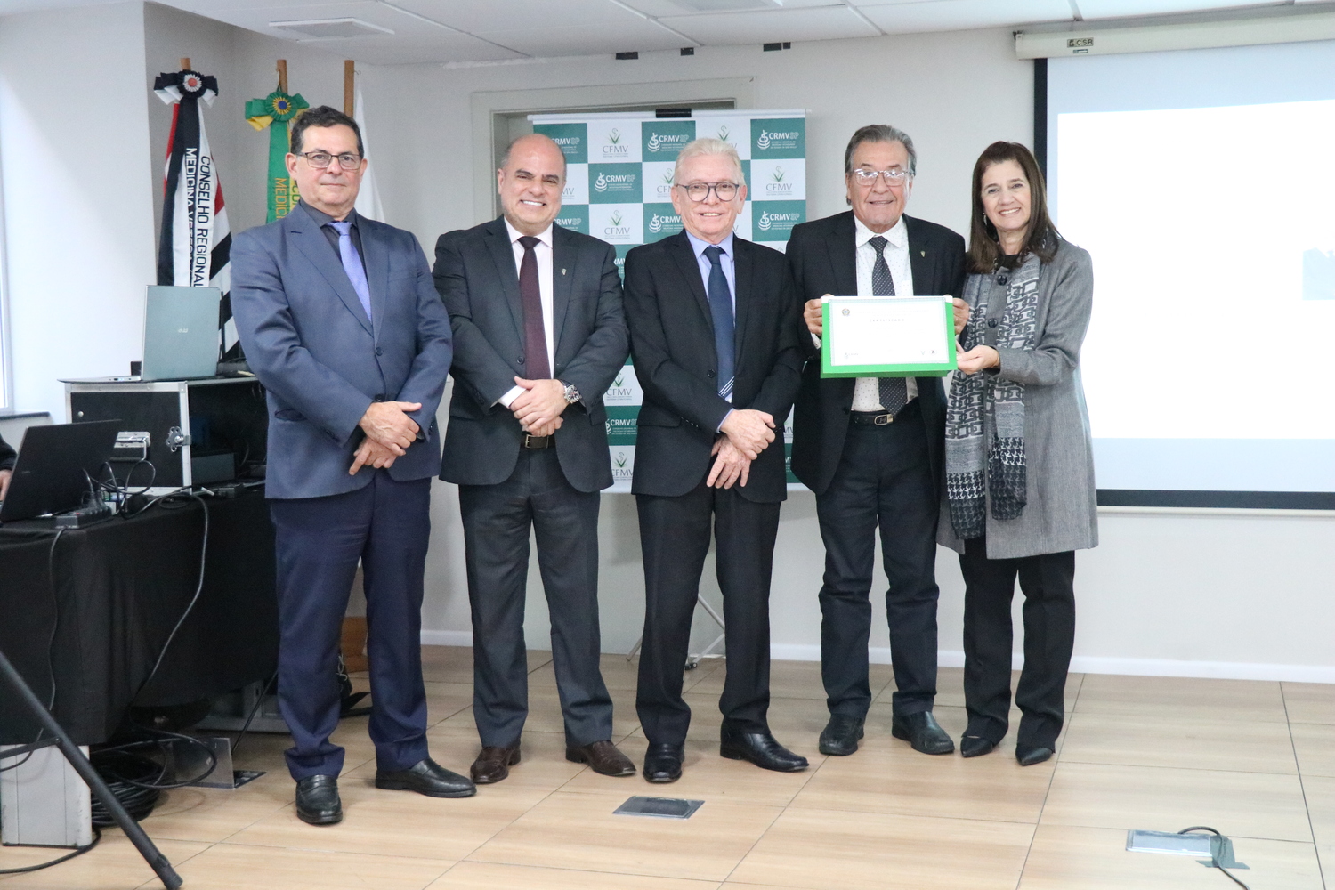 No palco, os membros da Diretoria Executiva do CRMV-SP posam ao lado de um dos integrantes da Comissão Técnica de Representantes Regionais, homenageado com certificado em reconhecimento ao trabalho desempenhado.