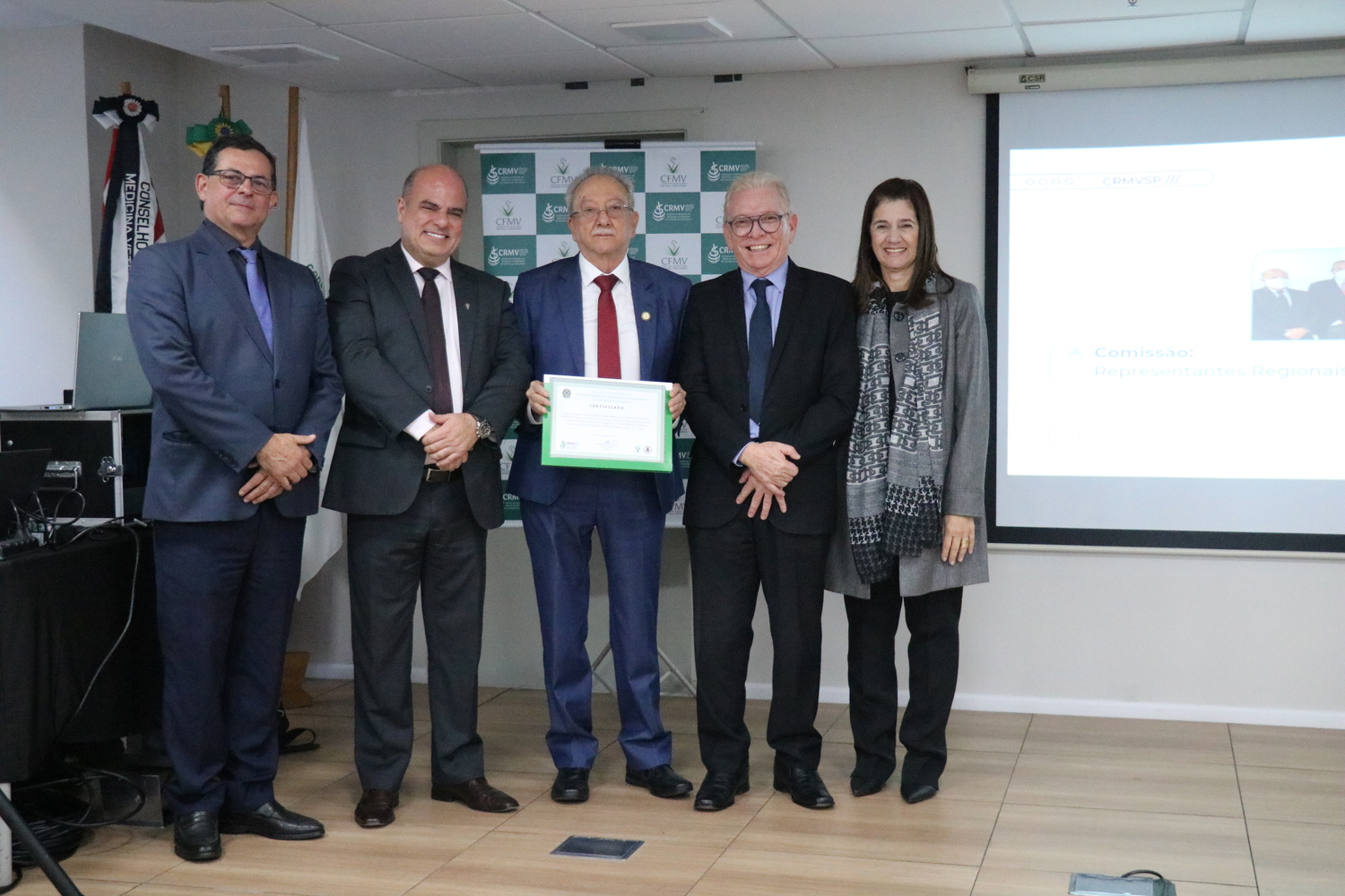 No palco, os membros da Diretoria Executiva do CRMV-SP posam ao lado de um dos integrantes da Comissão Técnica de Representantes Regionais, homenageado com certificado em reconhecimento ao trabalho desempenhado.
