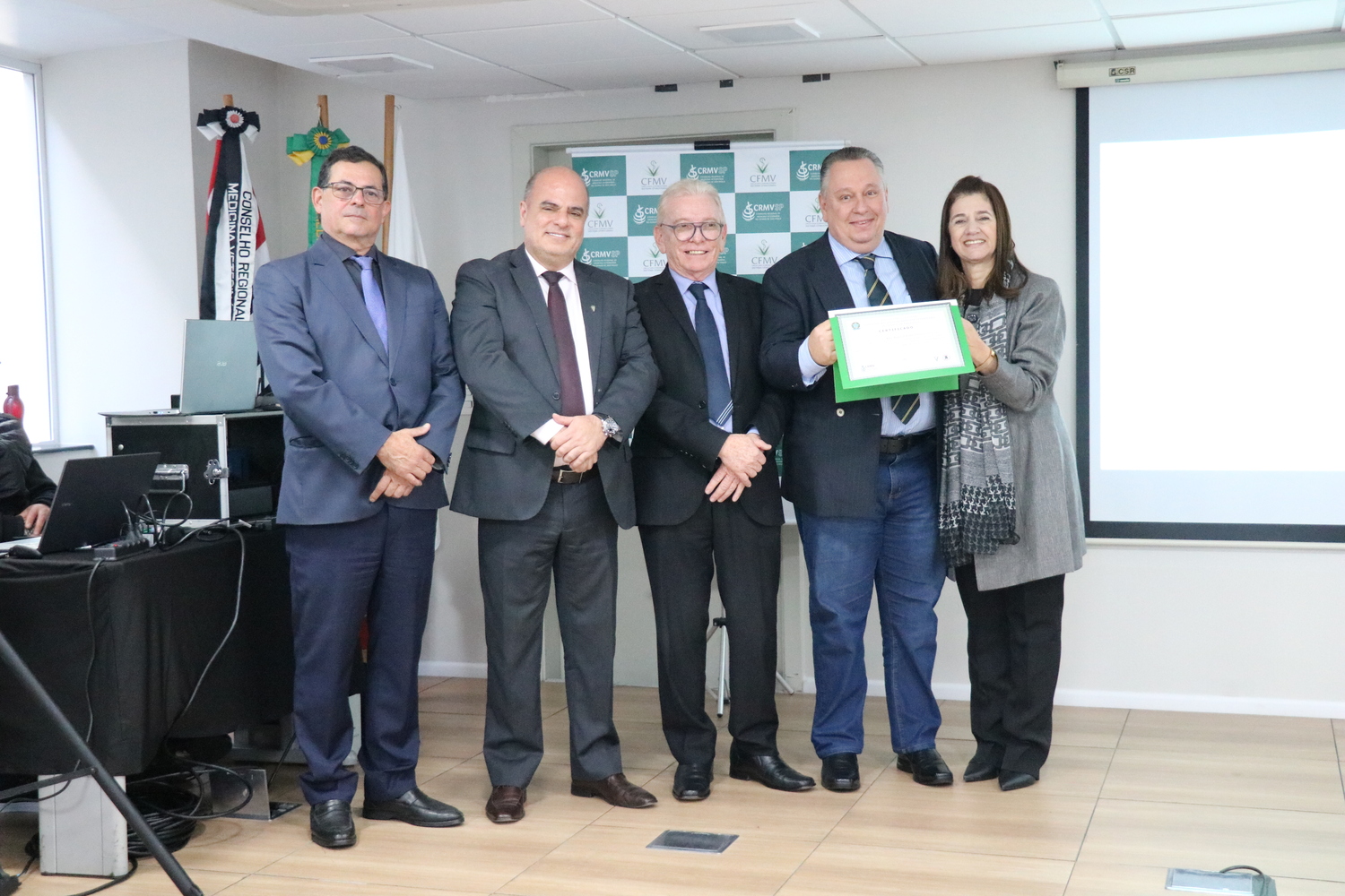 No palco, os membros da Diretoria Executiva do CRMV-SP posam ao lado de um dos integrantes da Comissão Técnica de Representantes Regionais, homenageado com certificado em reconhecimento ao trabalho desempenhado.