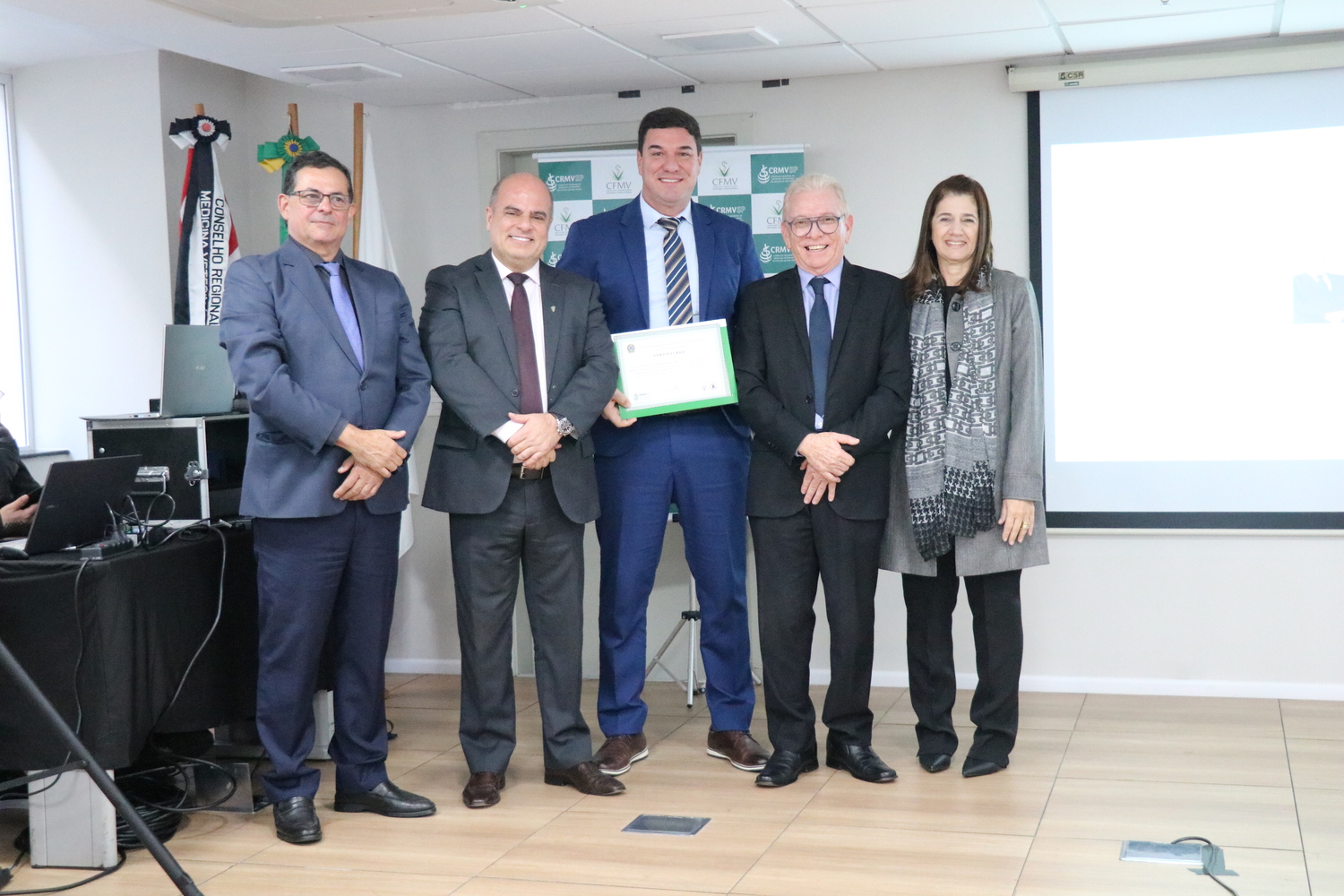 No palco, os membros da Diretoria Executiva do CRMV-SP posam ao lado de um dos integrantes da Comissão Técnica de Representantes Regionais, homenageado com certificado em reconhecimento ao trabalho desempenhado.