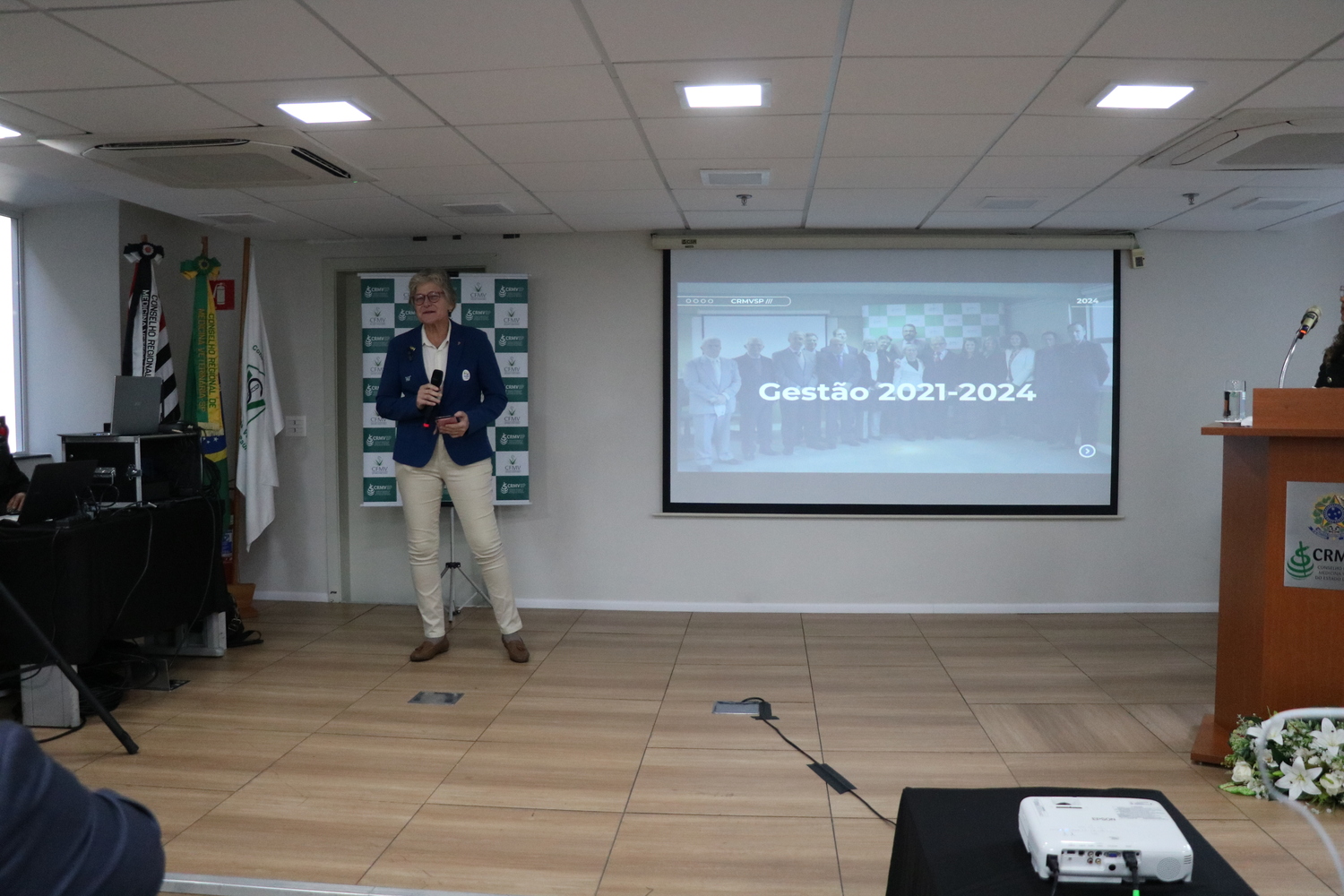 Uma das presidentes de Comissão Técnica fala ao microfone em nome das demais comissões e grupos de trabalho em agradecimento ao trabalho realizado ao longo da gestão e ao apoio da Diretoria Executiva.