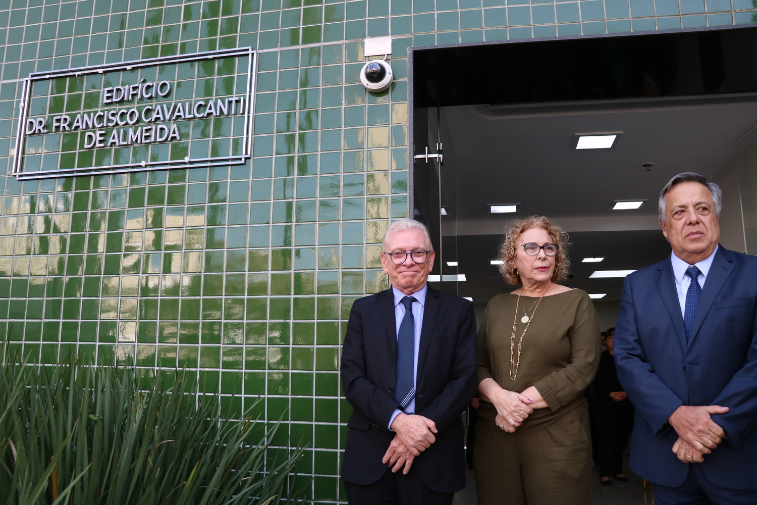 A esposa do homenageado, ao lado do presidente atual e de ex-presidente do CRMV-SP, posam ao lado da placa com o nome de Francisco Cavalcanti de Almeida gravado na entrada do edifício da sede do Conselho.
