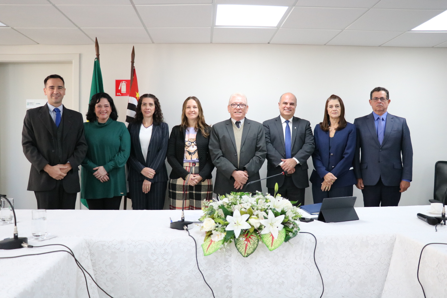 Oito pessoas, sendo os membros da nova e da atual gestão do CRMV-SP posam em pé lado a lado.