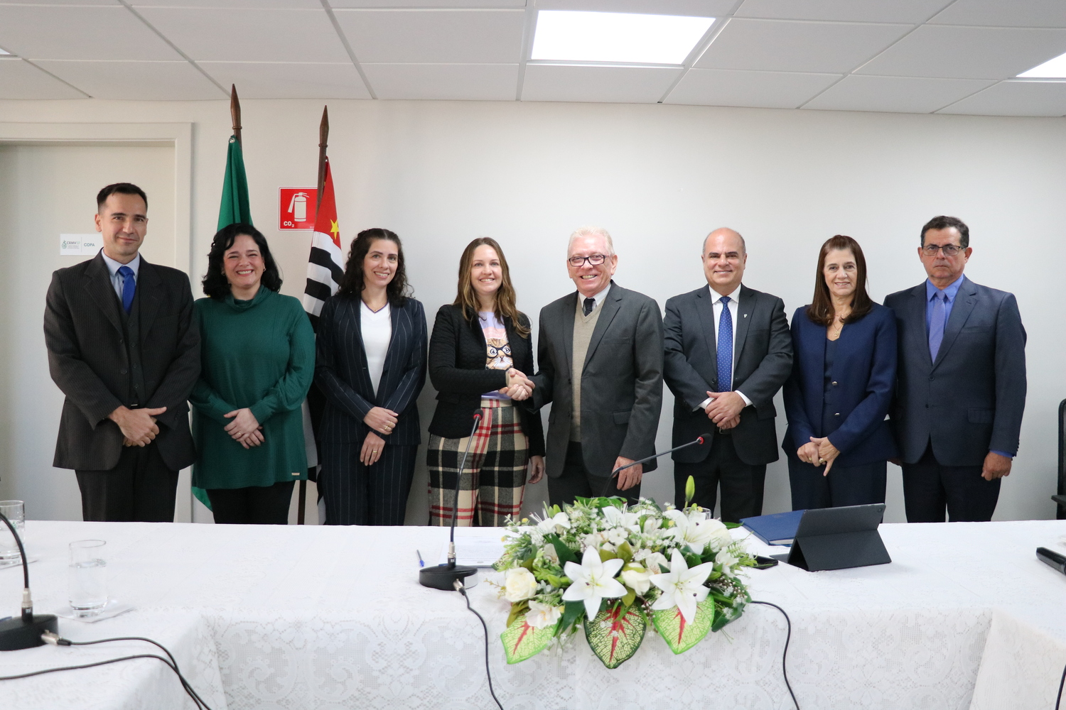 Membros das duas gestões, atual e empossada, posam para lado a lado, o presidente do CRMV-SP cumprimenta a nova presidente.