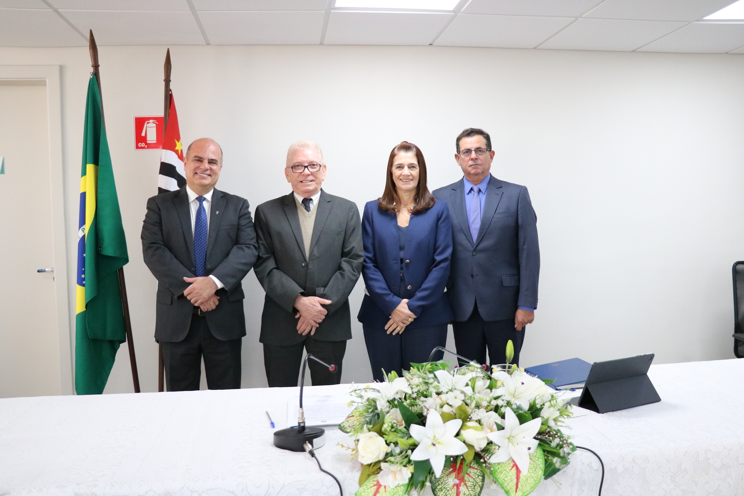 Membros da atual gestão, sendo três homens e uma mulher posam lado a lado.