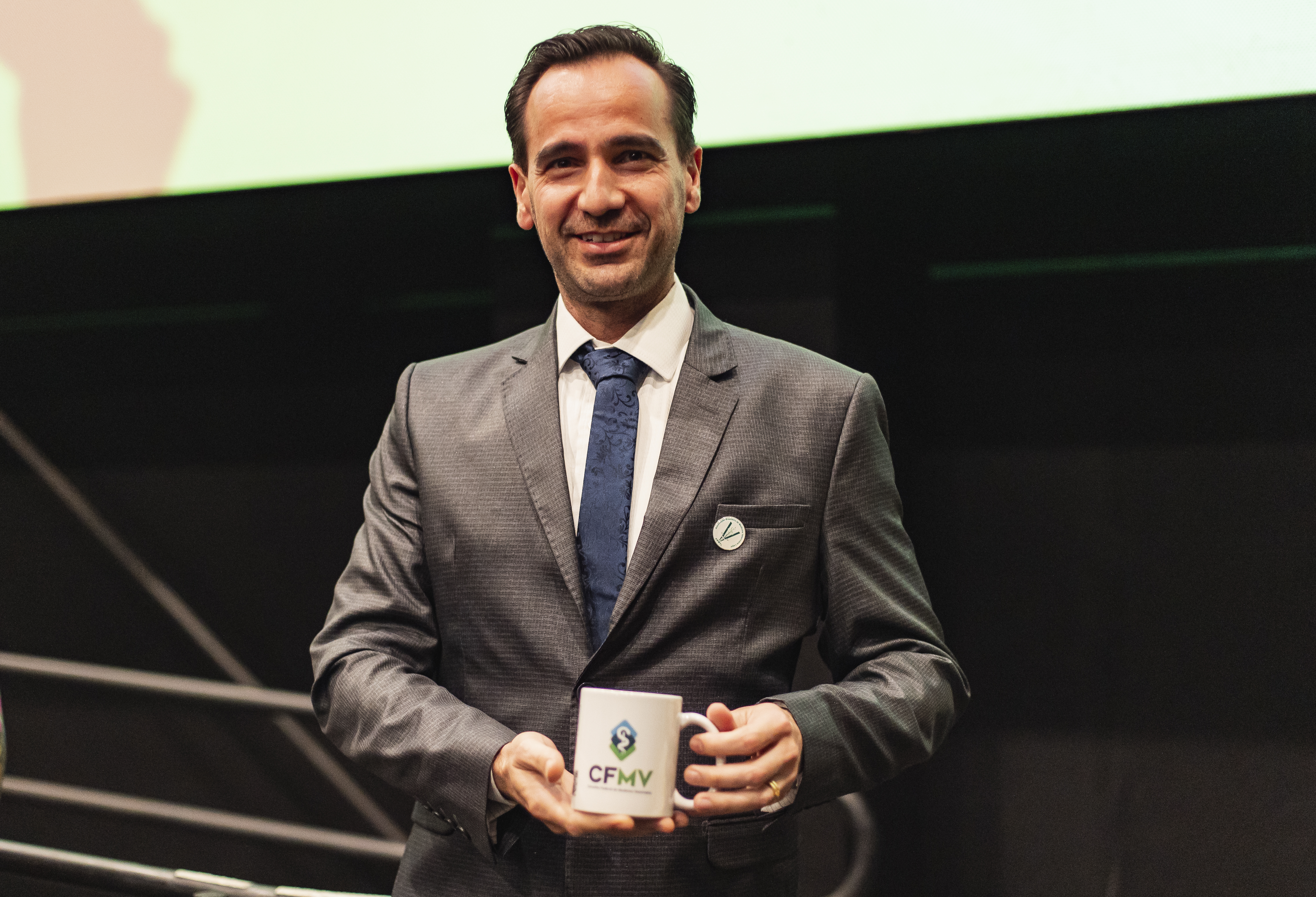 Homem segurando caneca com as duas mãos.
